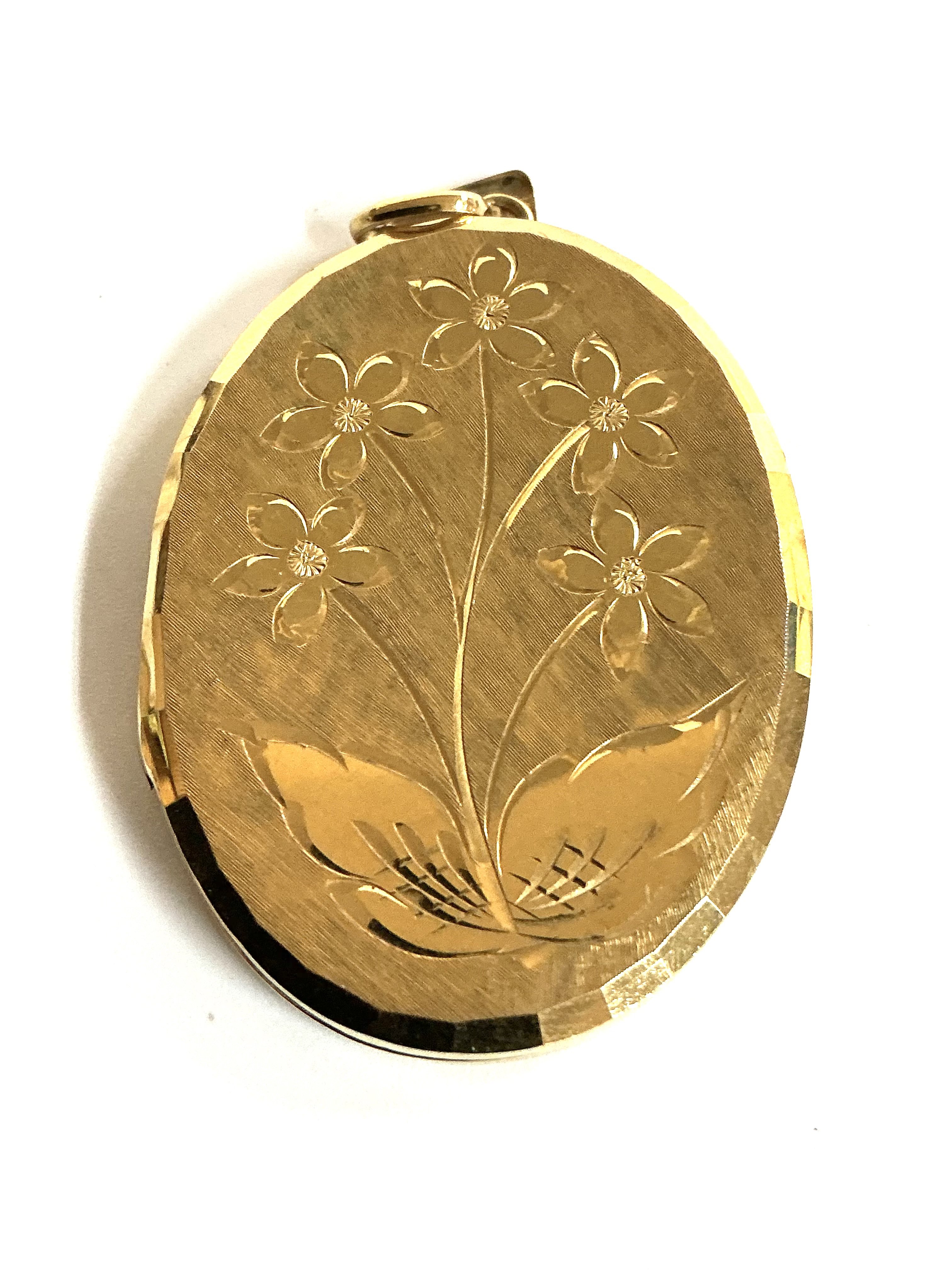 A large 9ct gold double locket with engraved floral decoration. (A)