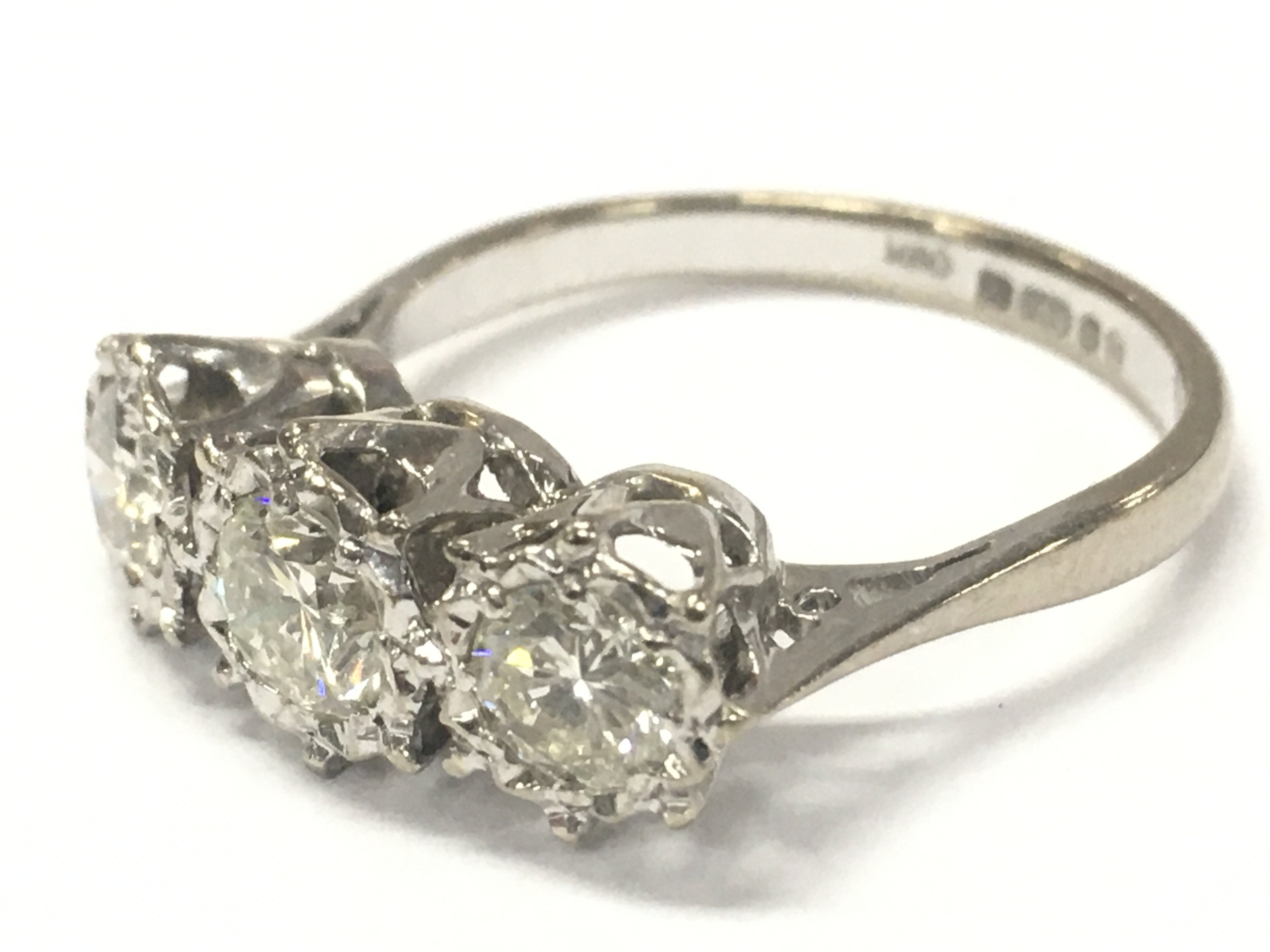 An 18ct white gold three stone diamond ring , size N. Central stone approximately 0.5ct. 3.8g total weight. Postage category A
