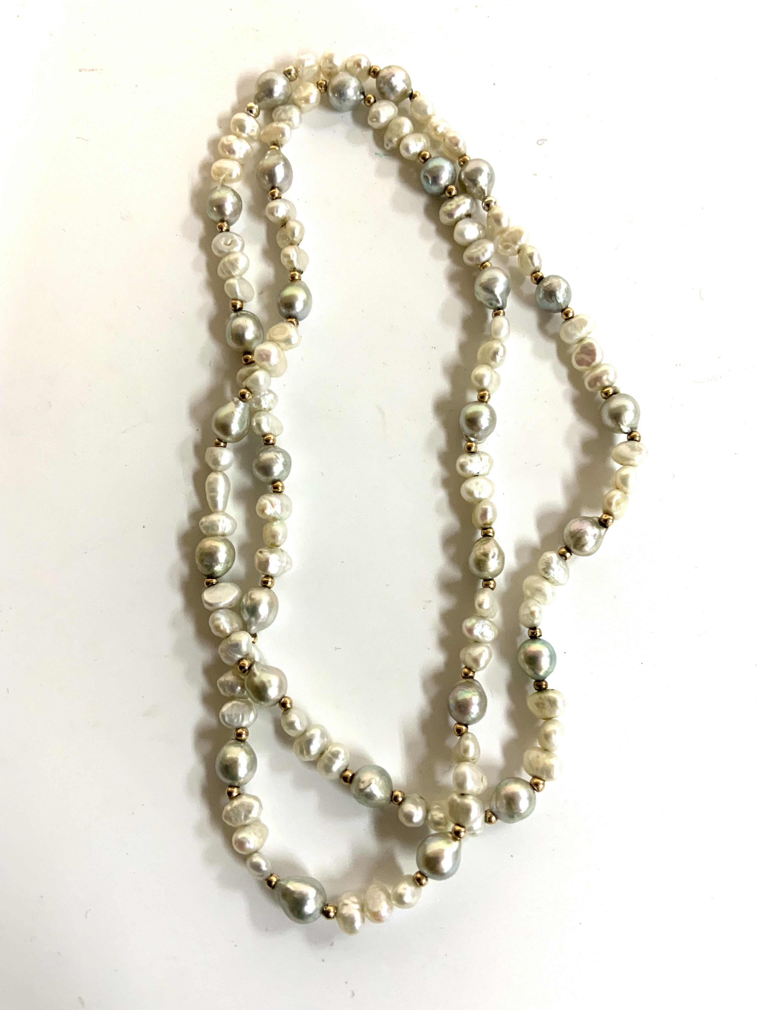 A multicoloured pearl necklace interspersed with gold beads. (A)