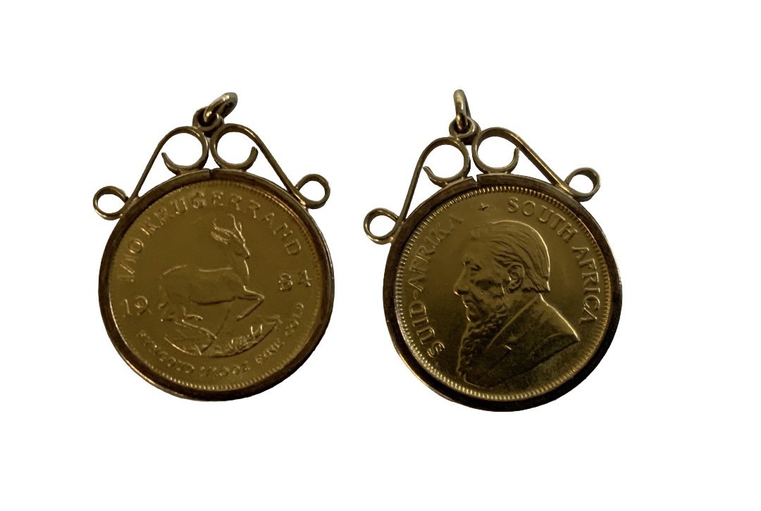 A 1984 1/10th Kruggerand coin with a 9ct gold coin mount. (A)