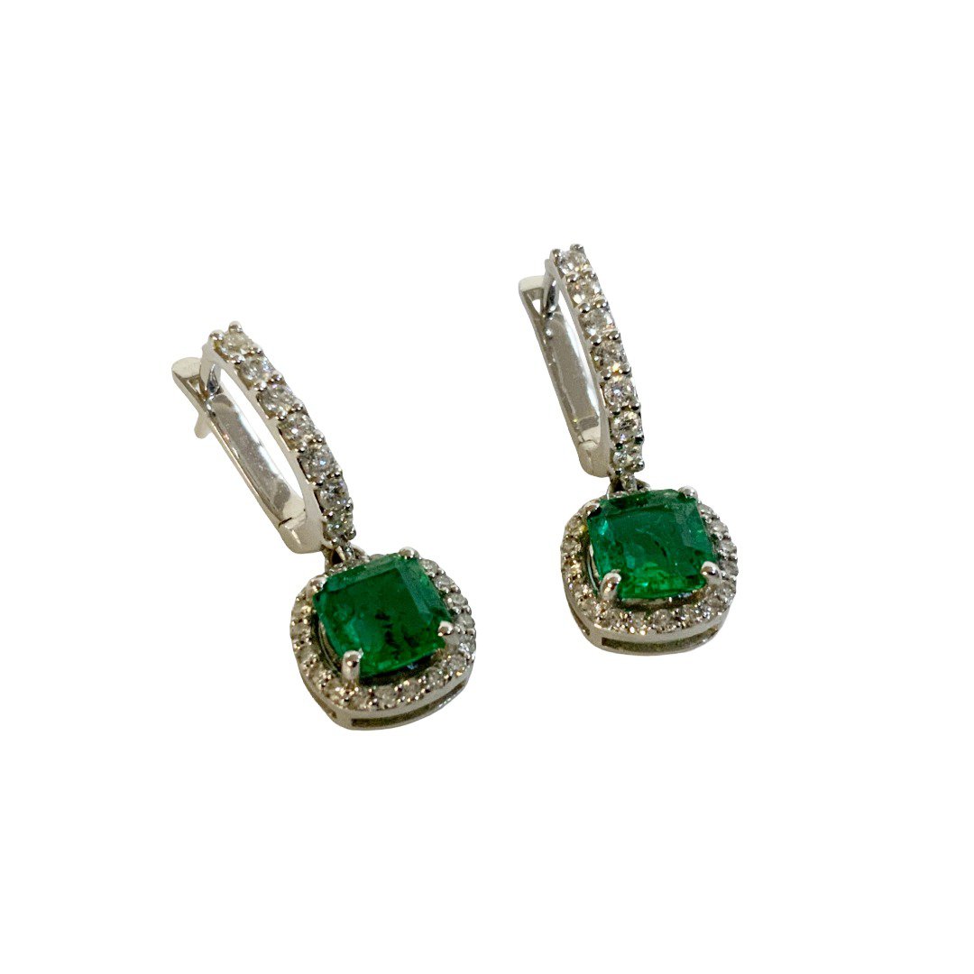 A pair of 18ct white gold and diamond set drop earrings each set with a cushion cut emerald. (A)