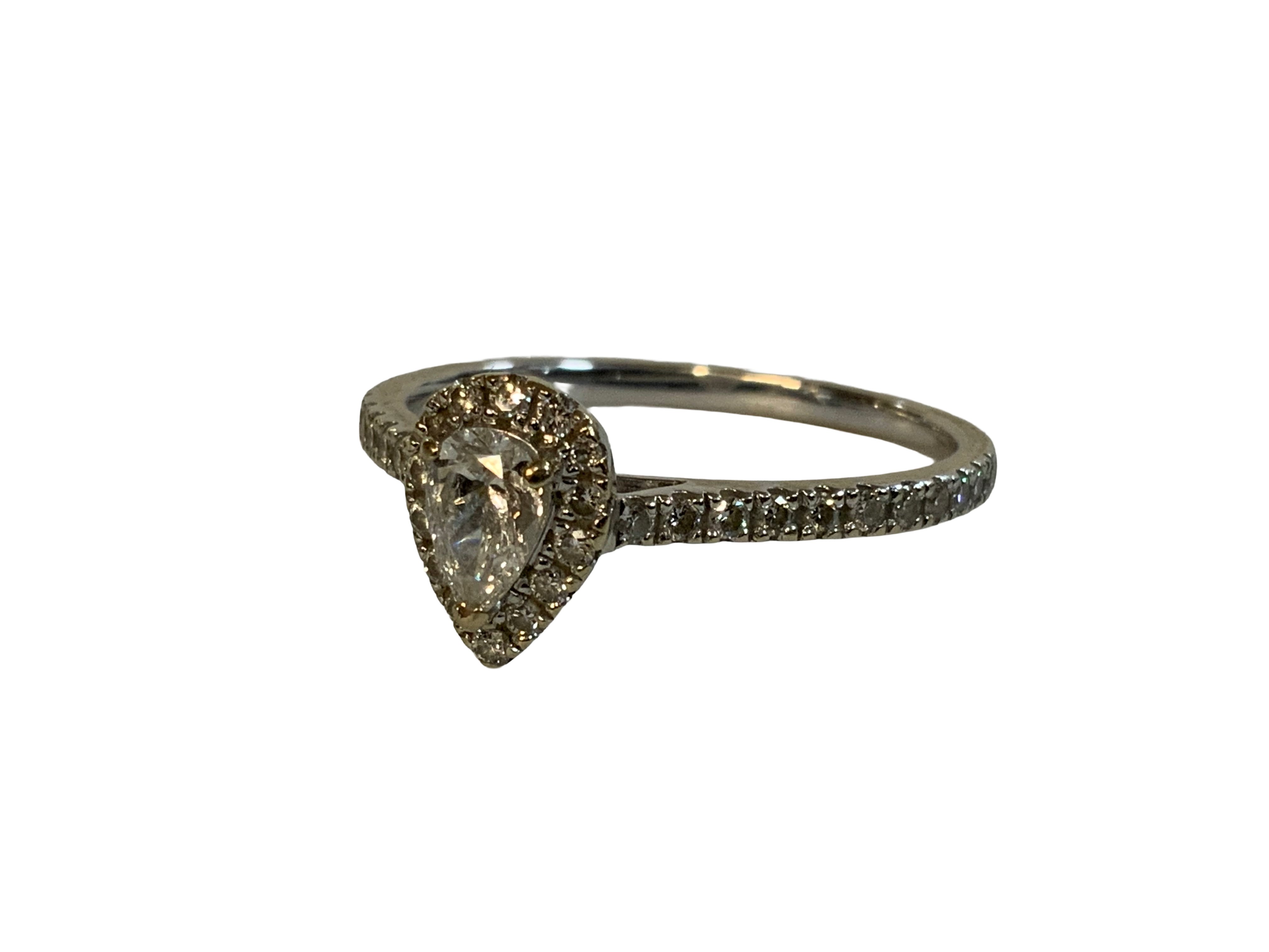 An 18ct pear shaped diamond surrounded by small diamonds. Size S (A)