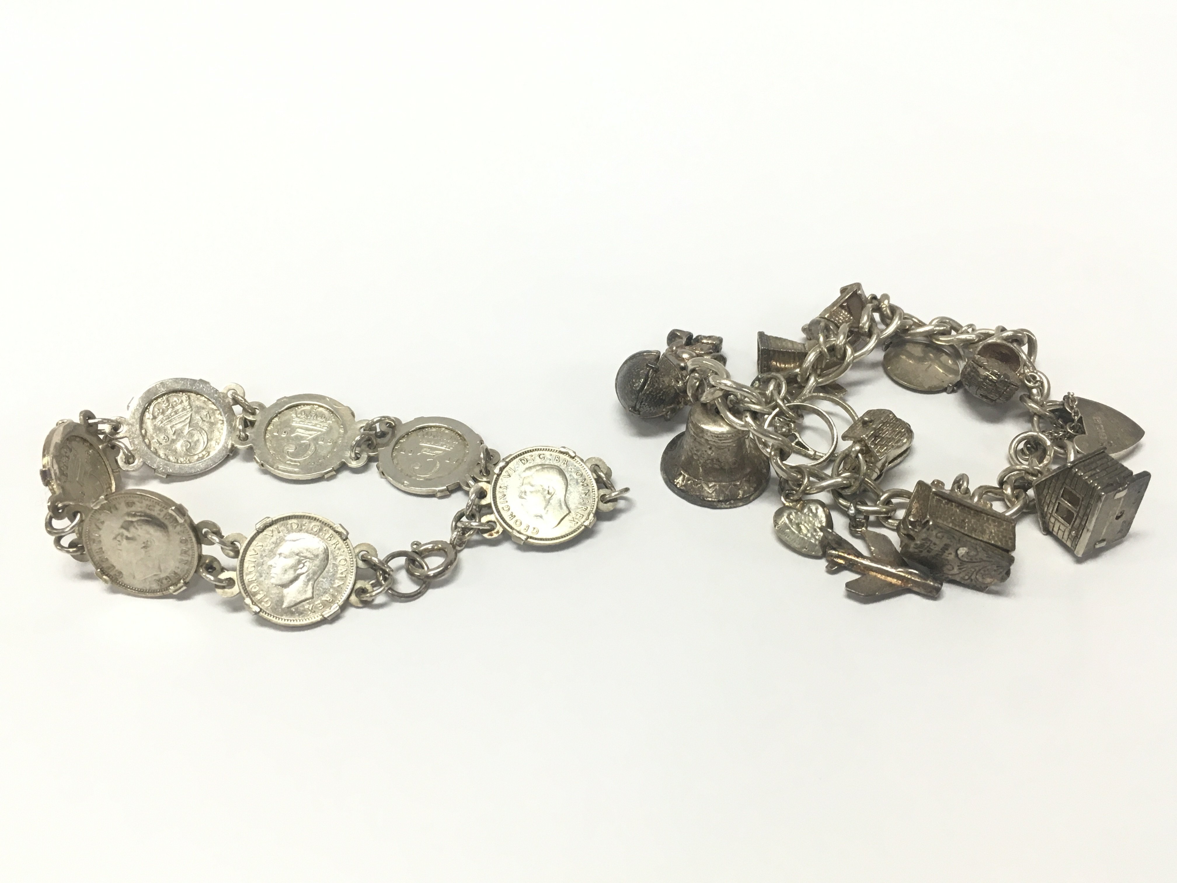 A silver charm bracelet and a silver three pence bracelet. Approximately 70.9g total weight. Postage category A