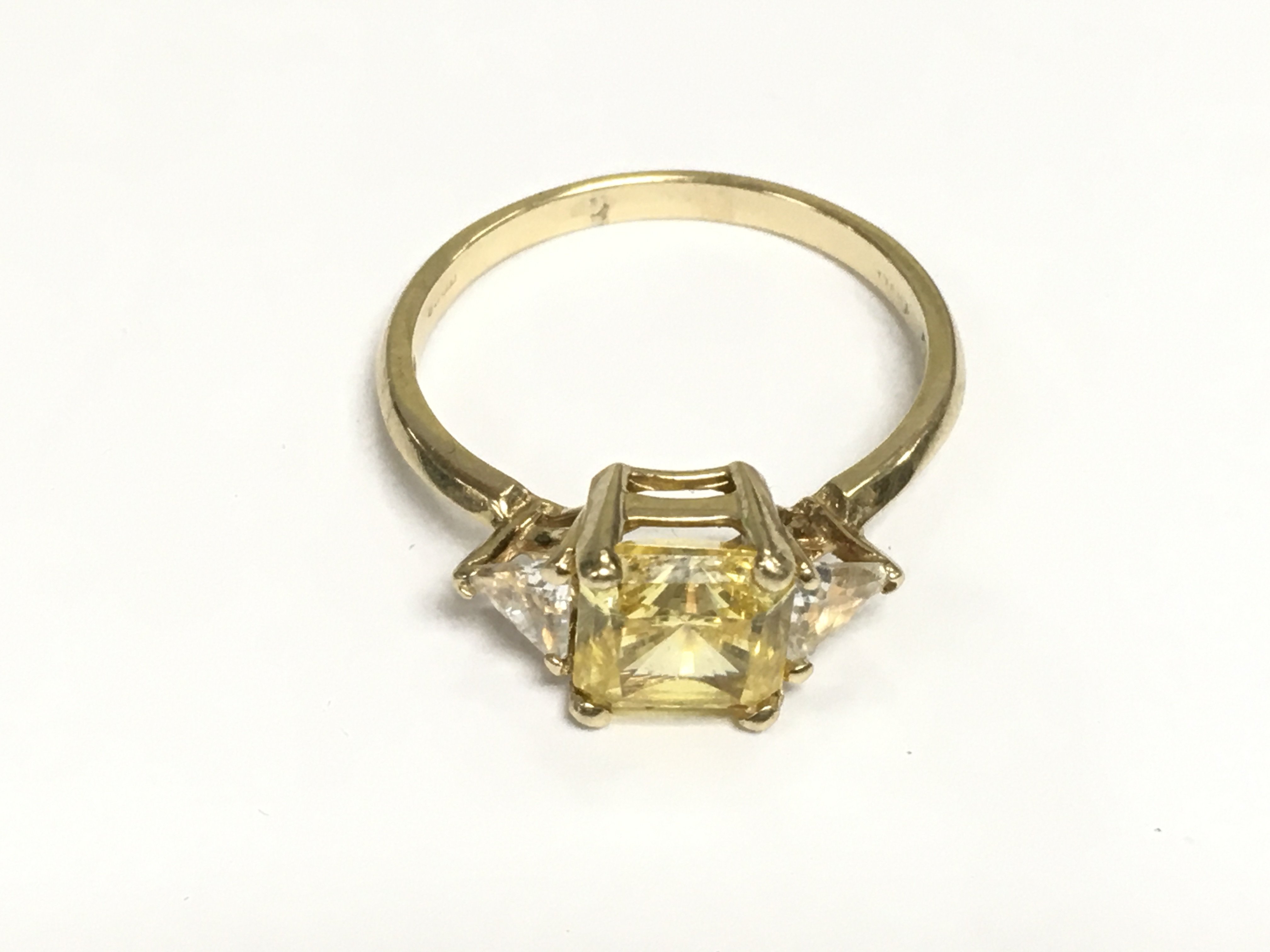 A 15ct gold ring set with a central citrine flanked by clear stones, approx 3.4g and approx size R. Shipping category A.