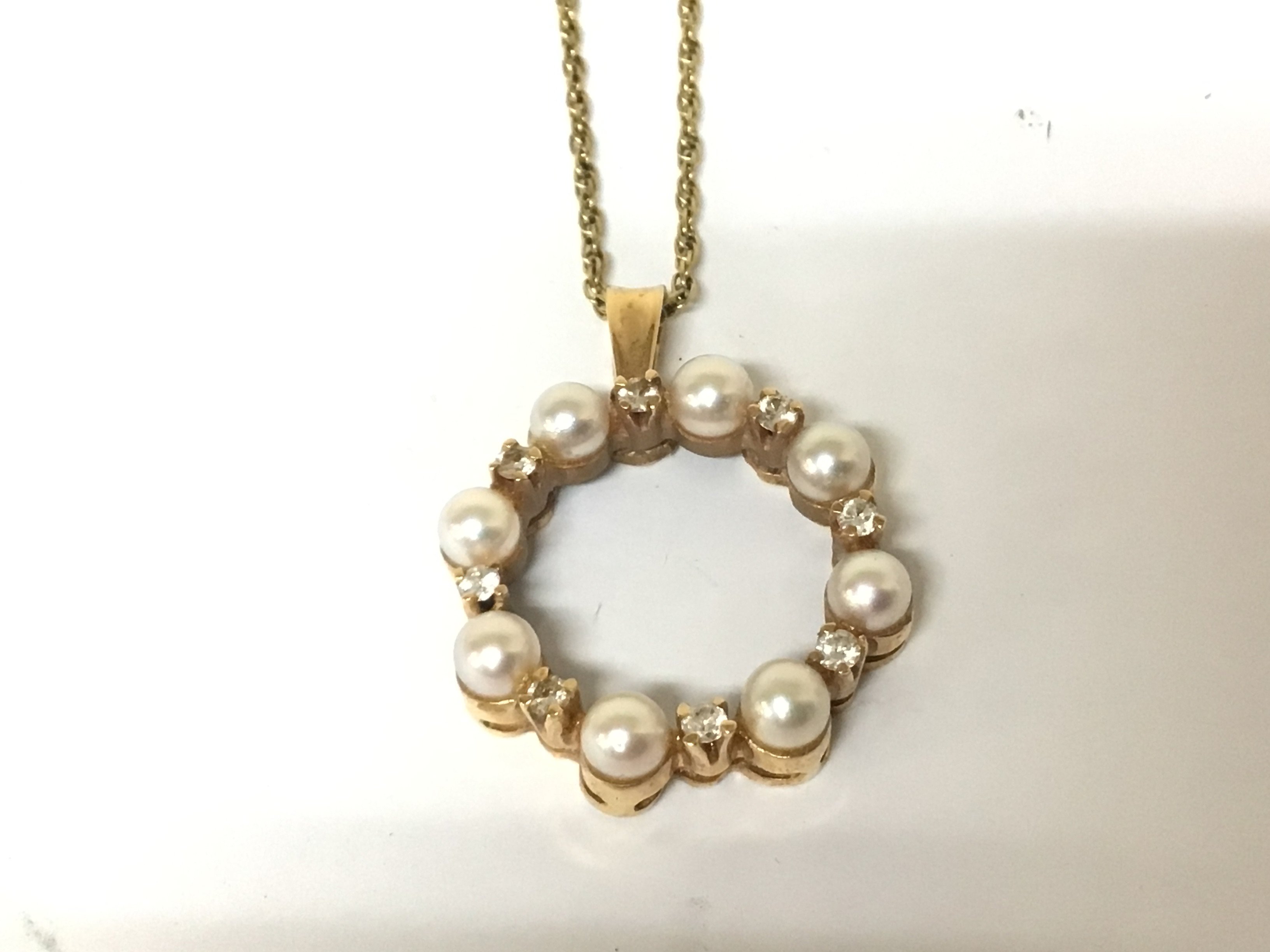 An 18carat gold pendent set with pearls and alternating diamonds. With attached 18carat gold chain. Total weight 8.5g