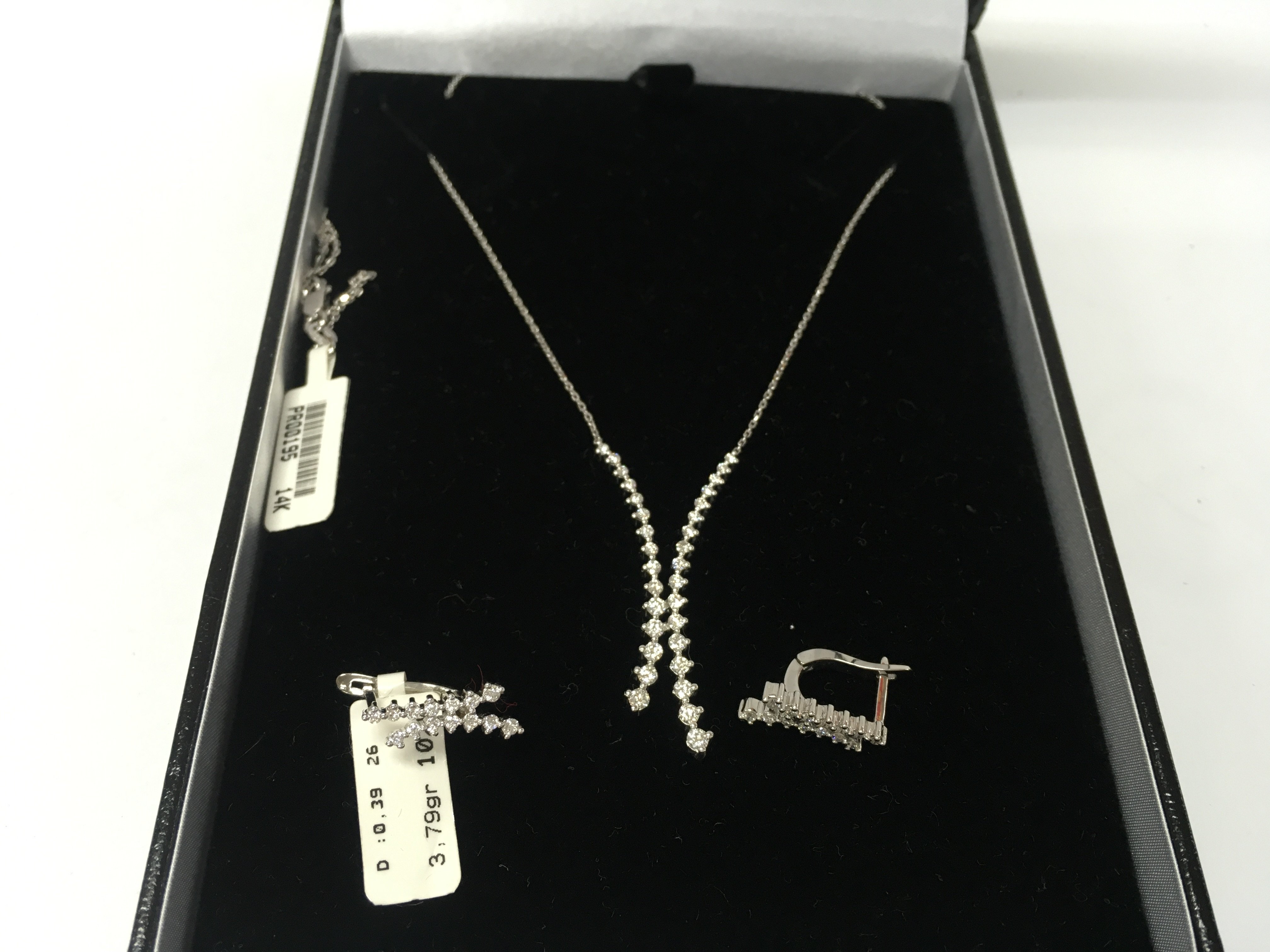 A 14ct white gold two row diamond necklace with matching earring. Postage B