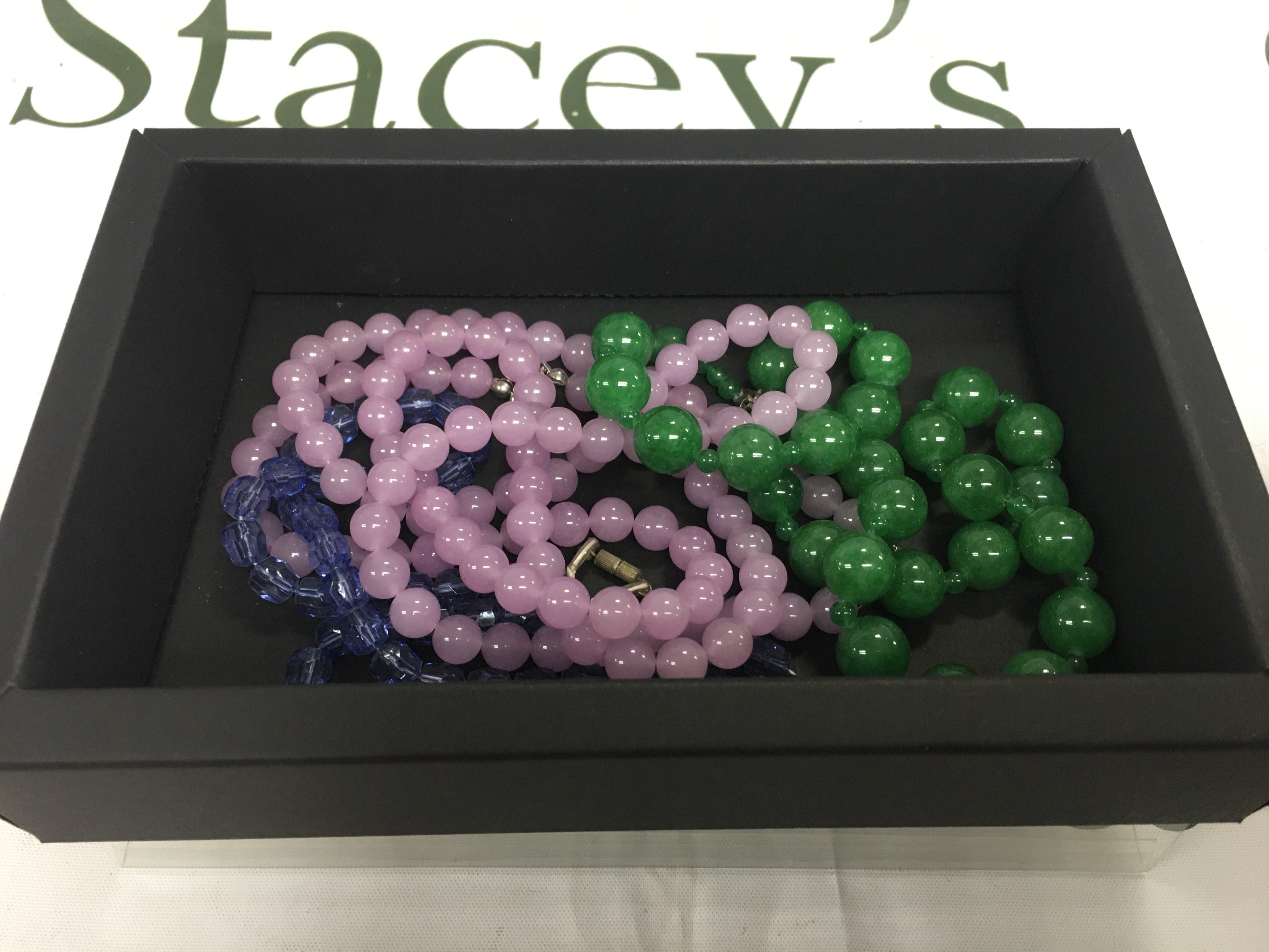 A box containing polished stone necklaces.