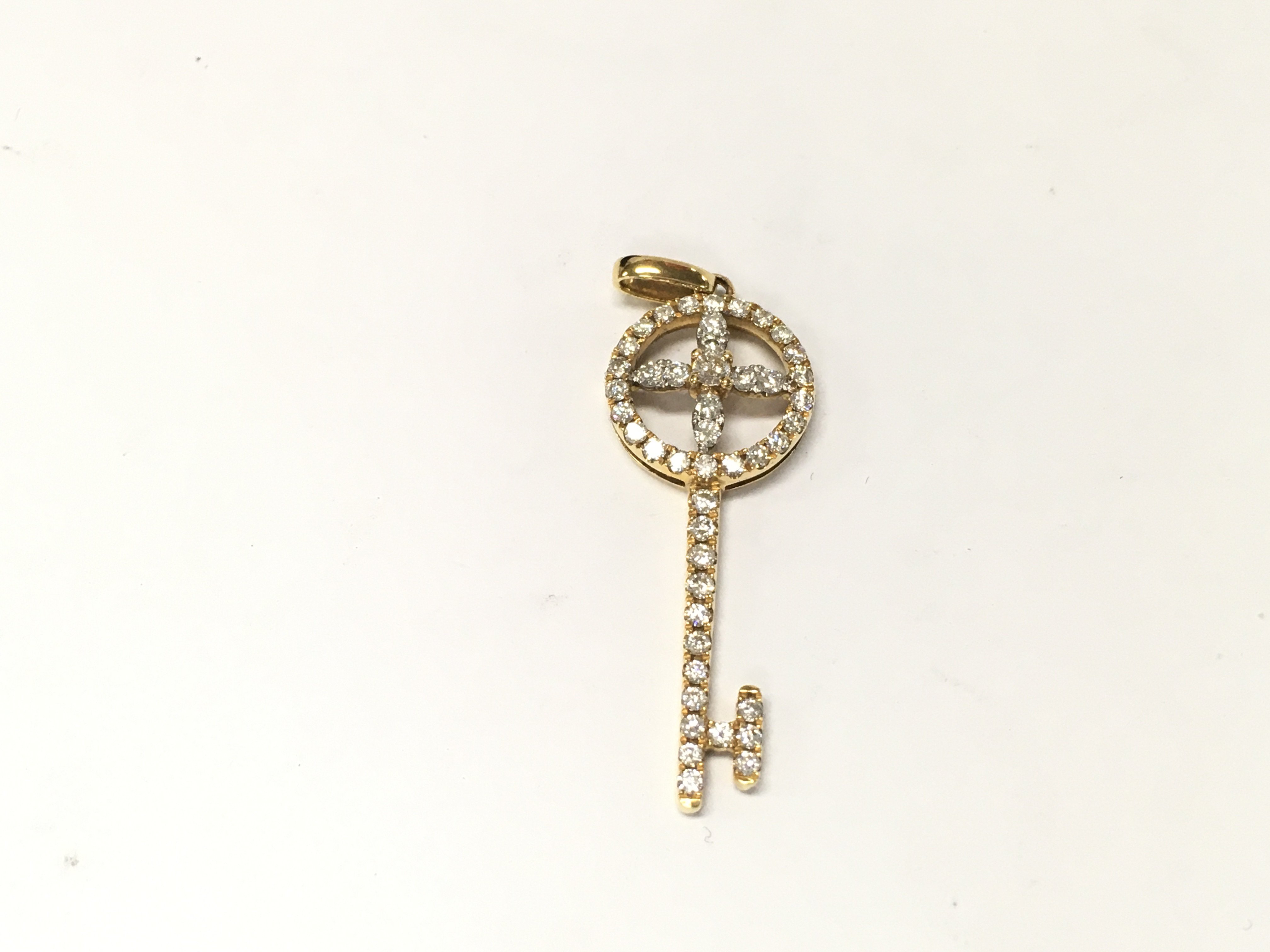 An 18ct diamond key pendant. 2.10g approximately