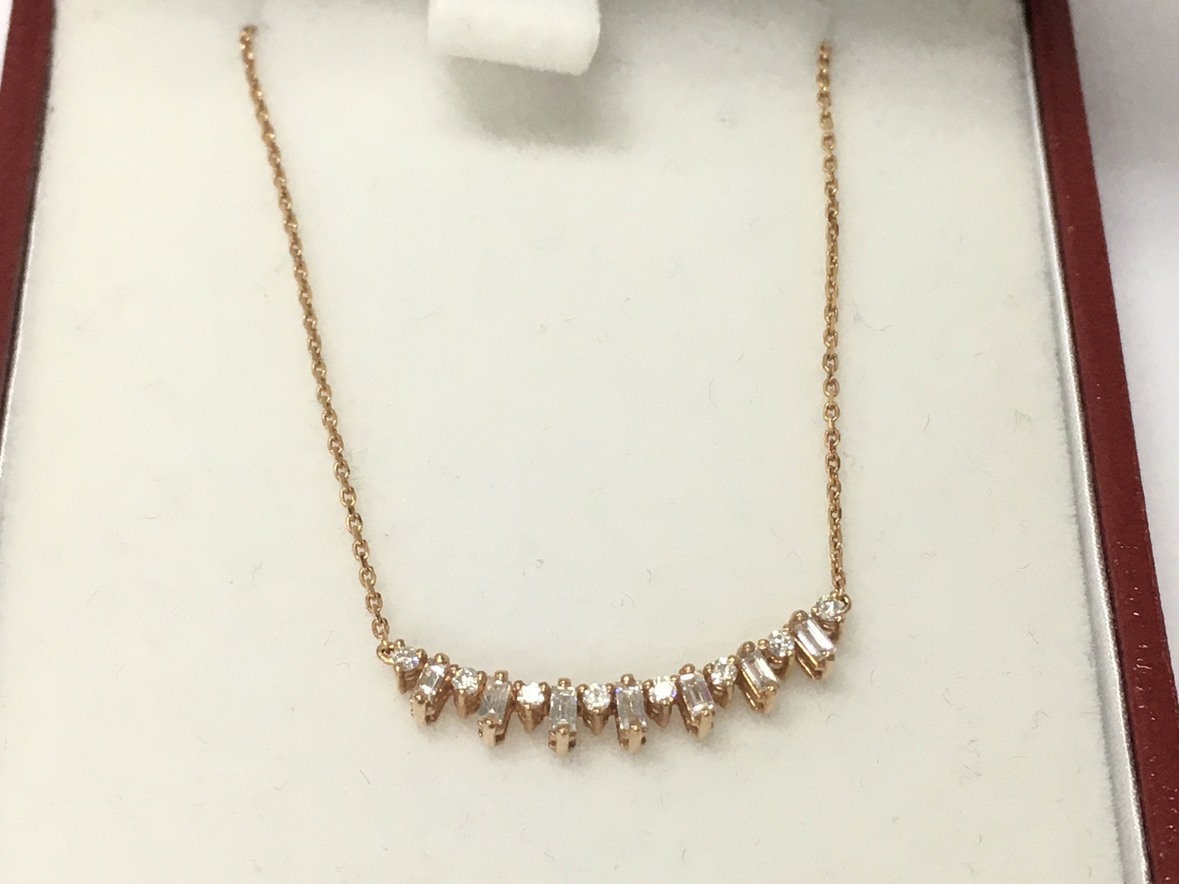 A 14ct rose gold diamond row necklace. Postage B
