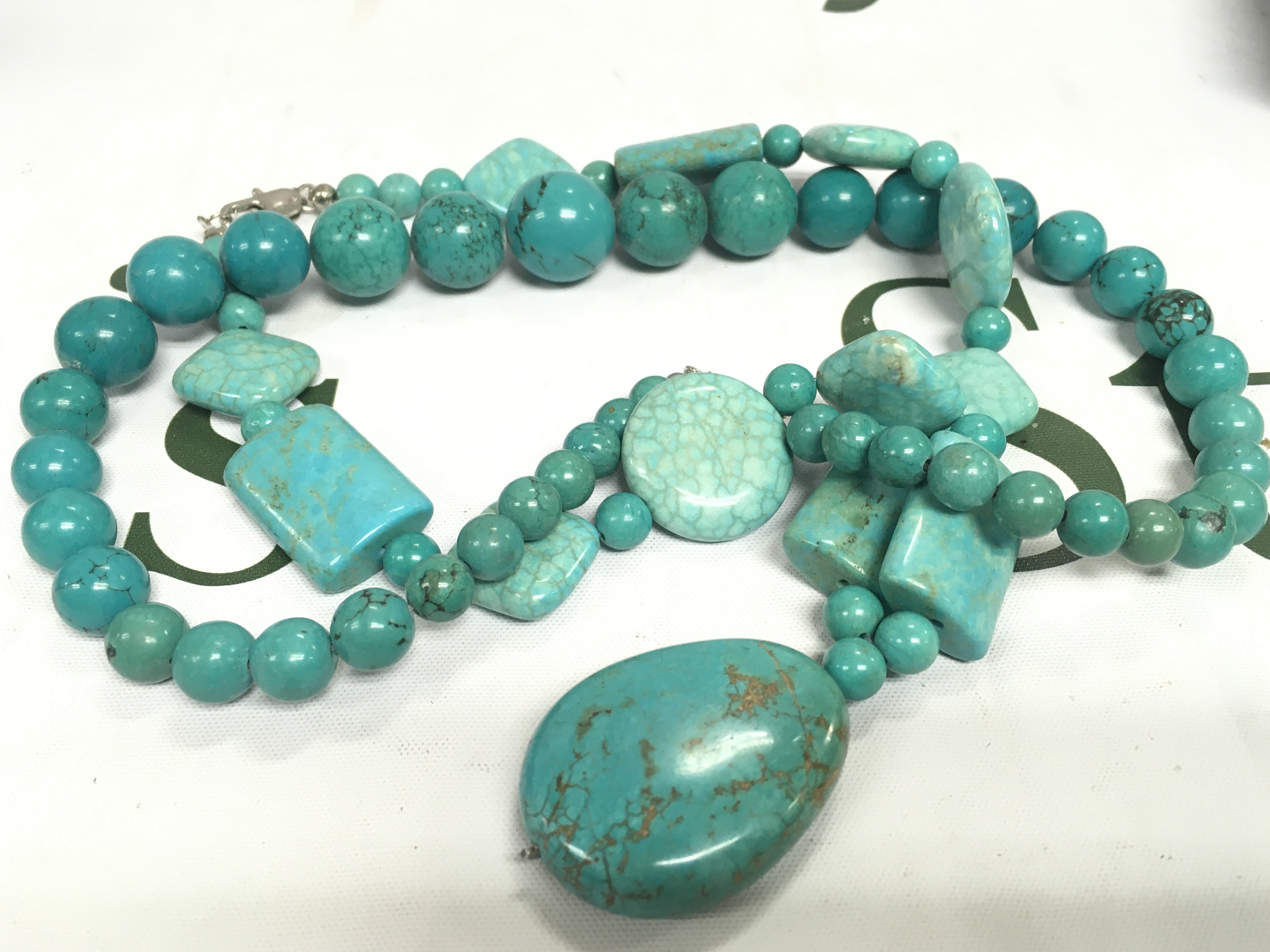 A box of polished stone necklaces.