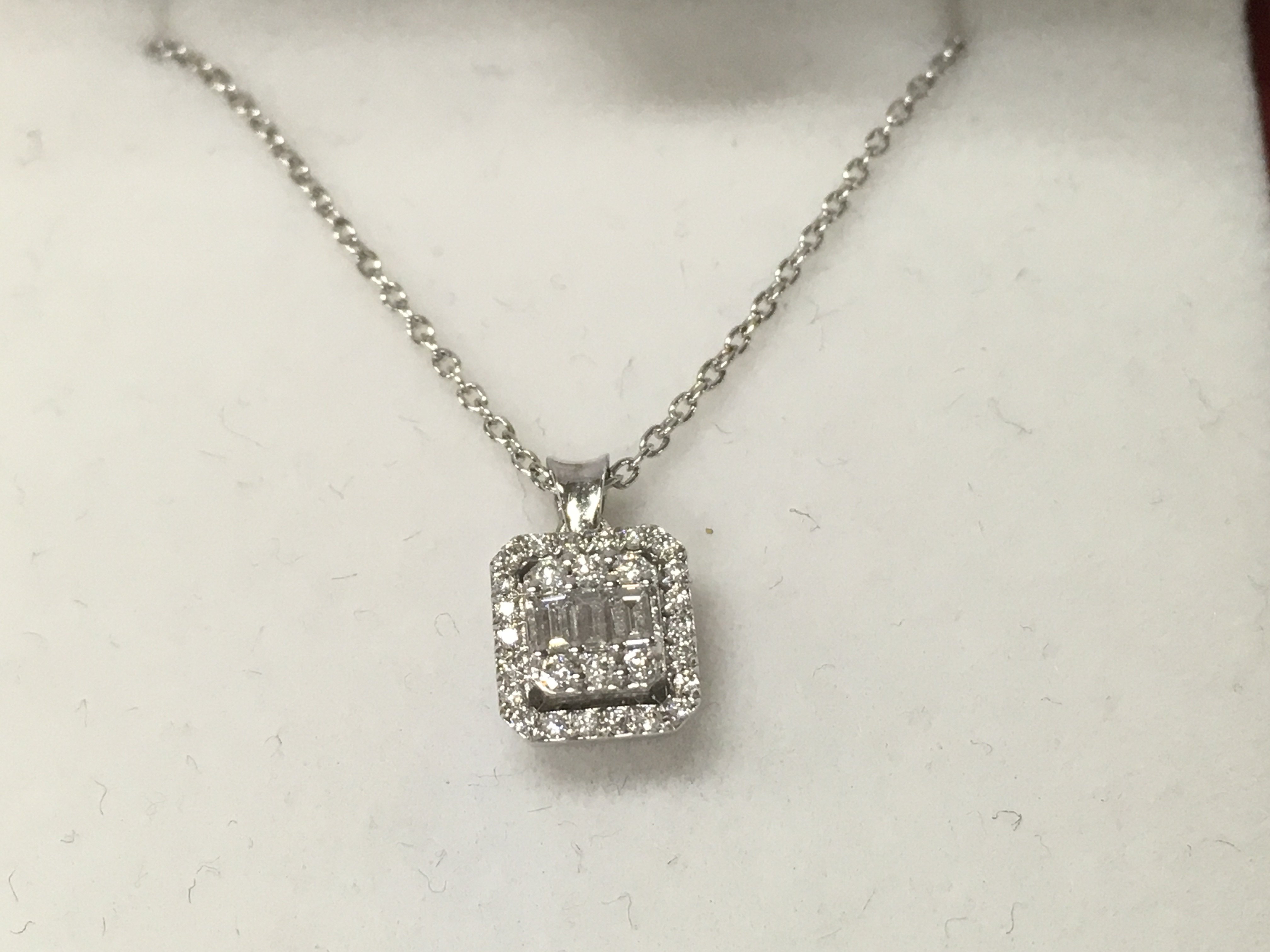 A 14ct white gold diamond square solitaire necklace.