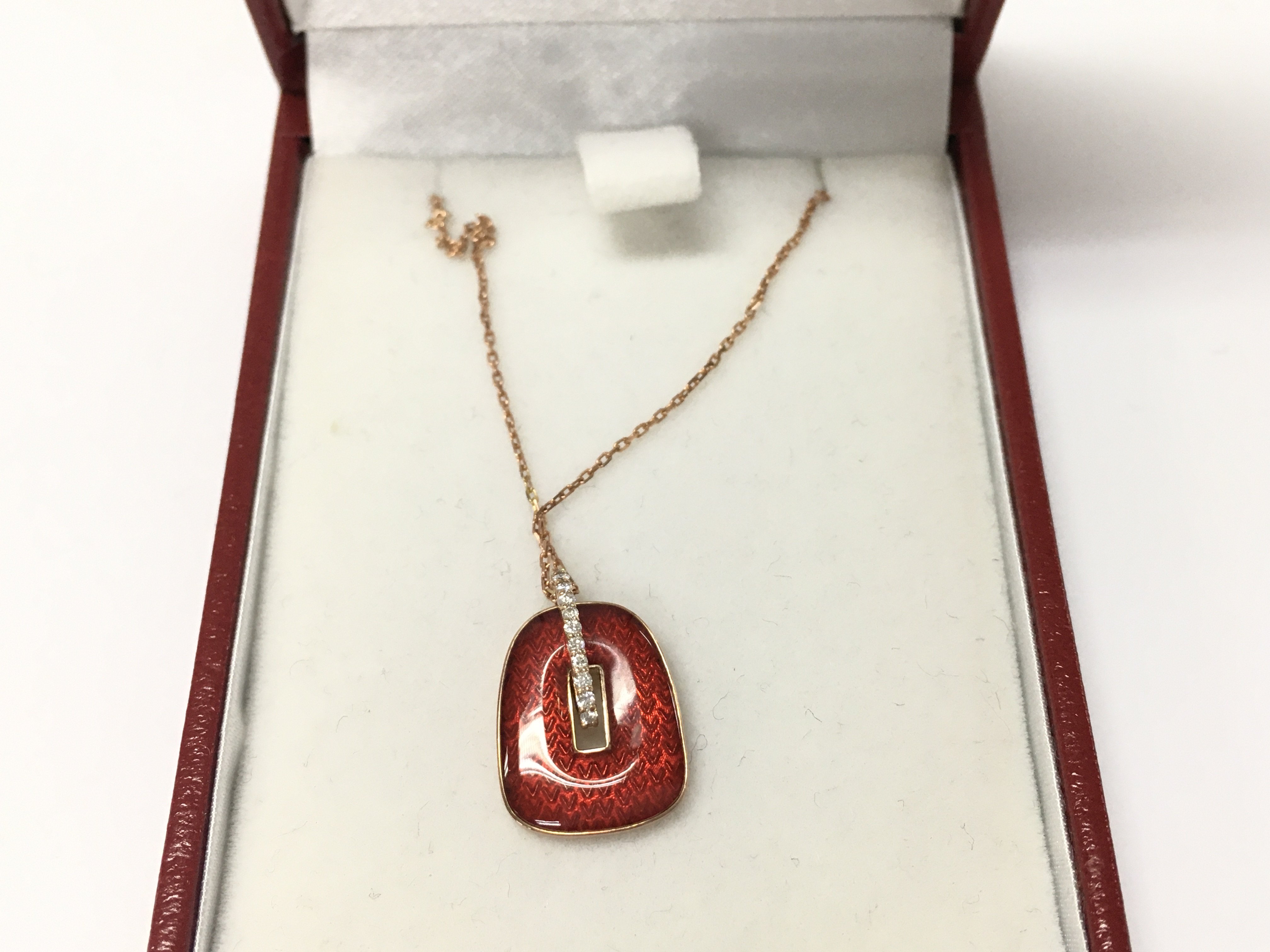 14ct rose gold chain with a red enamel and diamond pendant.