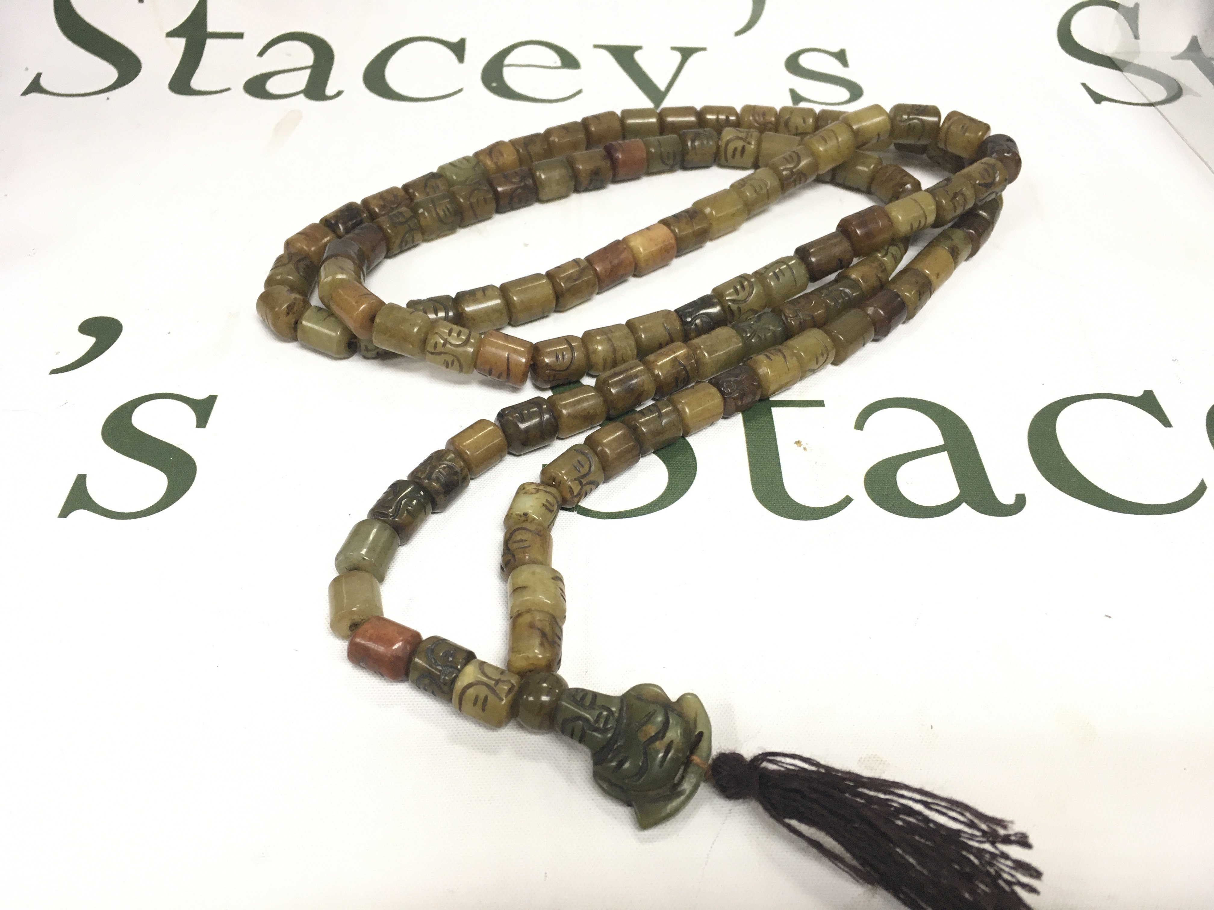 A 29&#2013266057۝ polished bead necklace with detailed beads and a Buddha style pendant.