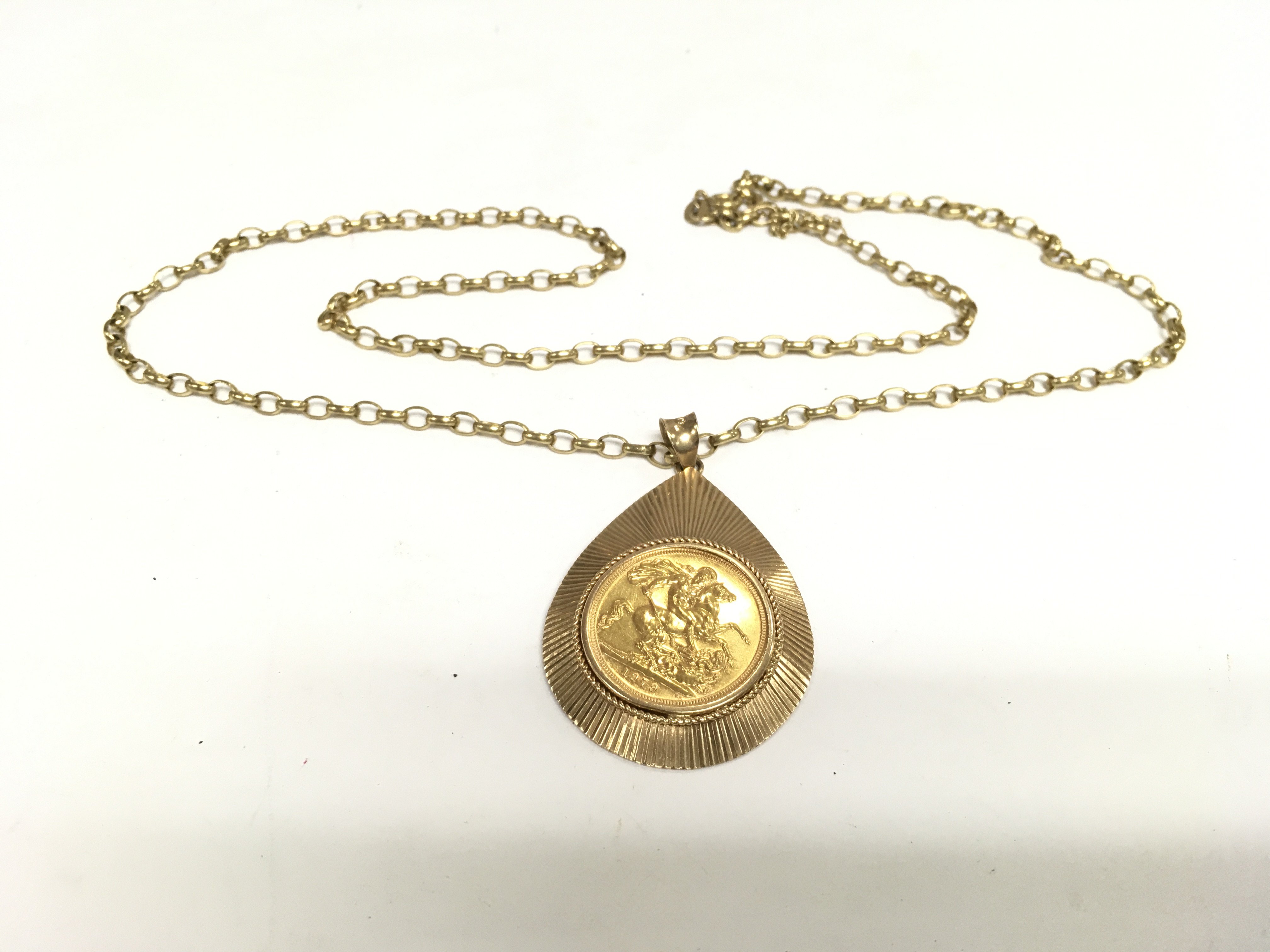 A gold sovereign housed within a 9ct gold pendant and suspended on a 9ct gold chain, approx 24.3g. Shipping category A.