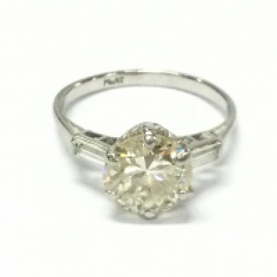 A platinum set diamond ring with 2.55ct round cut central stone and baguette cut diamond shoulders. VS2 and M colour.