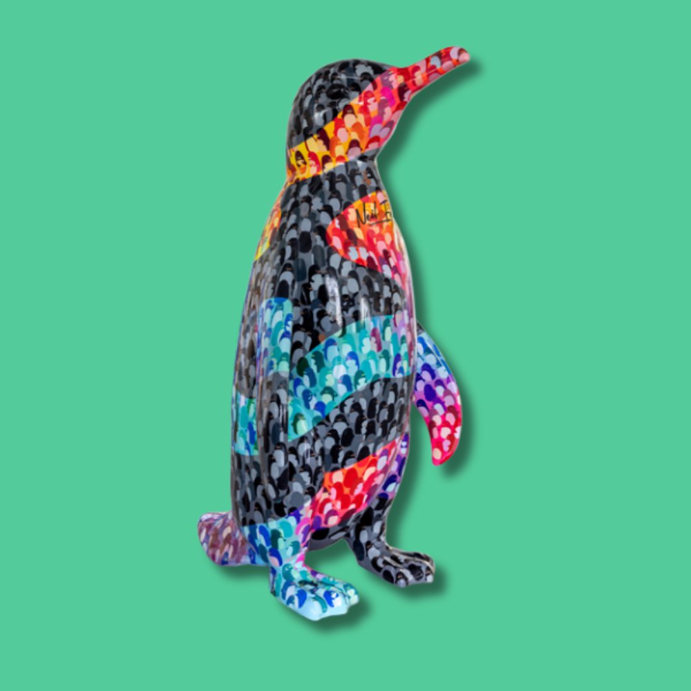 Wave of Diversity - Sponsor: First Bus East of England / Artist: Neil Fendell / This artwork represents the balance between unity and individuality. The black and white penguins symbolise our shared experiences, while the wave of vibrant penguins highlights our unique qualities. Together, they celebrate the beauty of diversity within sameness. Neil is a passionate illustrator with a love for local art projects. Each creation is a testament to his unique ability to infuse a quirky charm and a retro aesthetic into his designs, resonating deeply with audiences. His work reflects a playful yet meaningful approach to art, blending community connection with creative expression. - Height 1600mm width 890mm Depth 1090mm weight 30kg