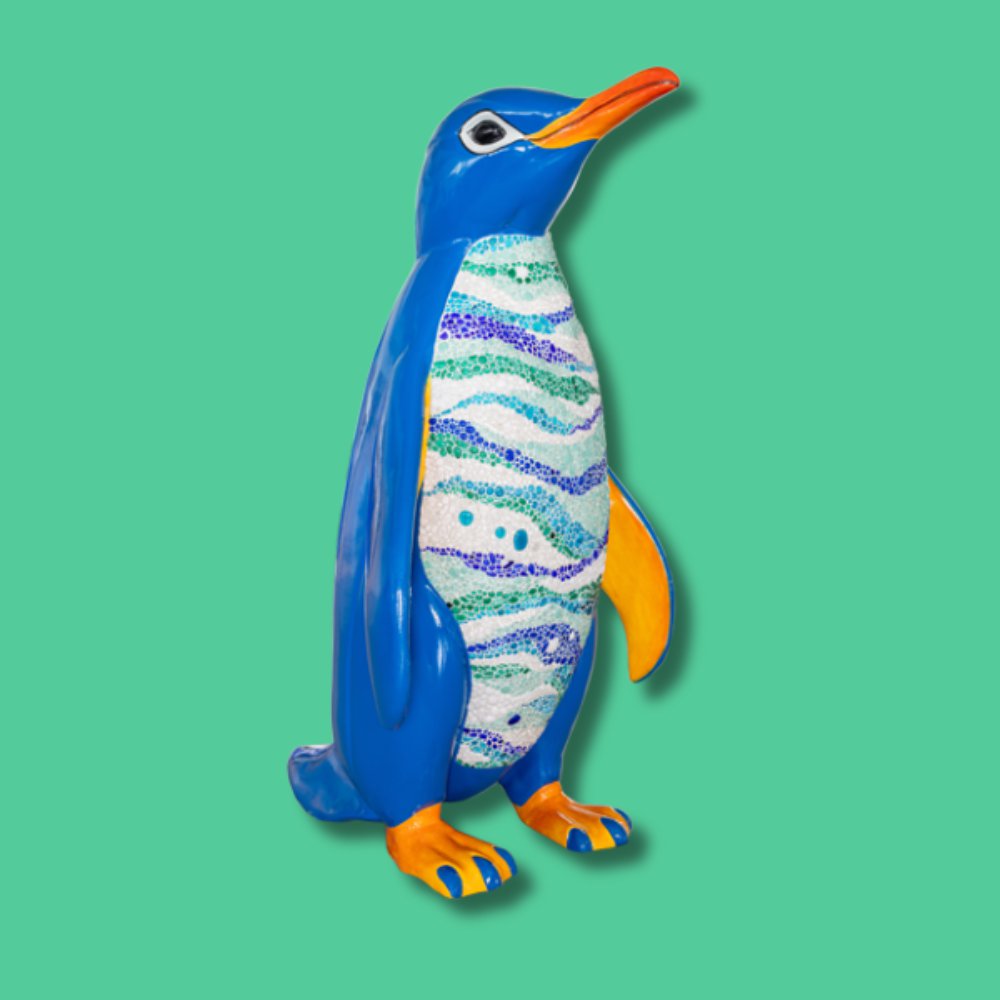 Kai the Recycled Glass Penguin - Sponsor: Ipeco Holdings Limited / Artist: Louise Truslow / Kai, meaning 'sea', is adorned with a mosaic made from recycled, lead-free crystal glass fragments, kiln-fired for smoothness. Artist Louise powers her kiln with solar panels, sustainably transforming discarded glass into vibrant beads. The mosaic spans Kais front, from neck to legs, with a small motif on his back; the rest is painted in acrylics. The design draws inspiration from aerial Antarctic Ocean photography. Louise was born and raised in Leigh-on-Sea and has stayed connected to the area despite living abroad for many years. She returned around eight years ago and now has a studio there. Louise began painting professionally while living in Bangkok and has had an international career, exhibiting in both the Far East and the UK. - Height 1600mm width 890mm Depth 1090mm weight 30kg