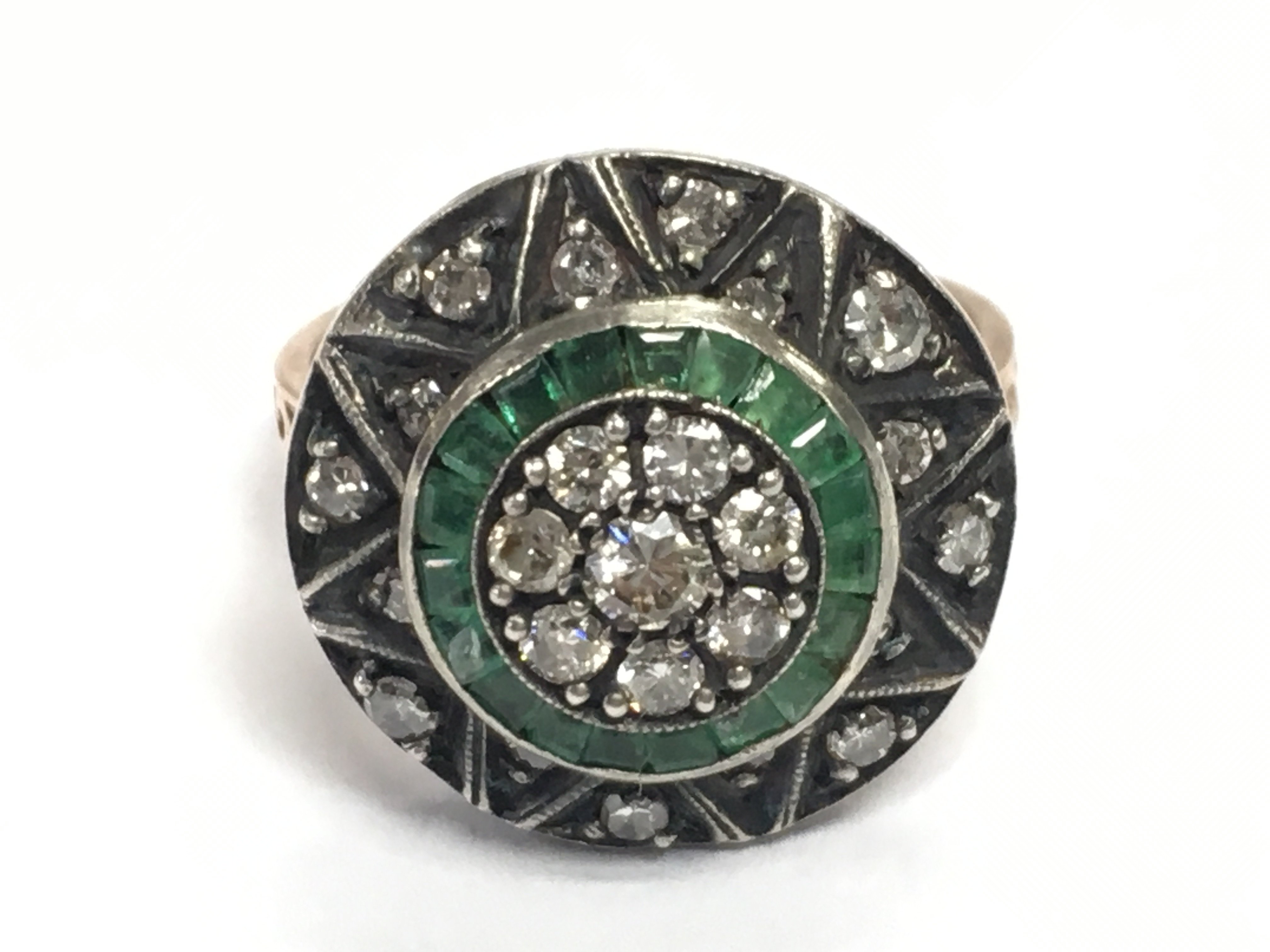 An 8ct rose gold large target style dress ring set with square and mixed-cut emeralds and RBC diamonds. Emeralds 0.35ct approx. Diamonds 0.50ct approx. 6.50g total weight