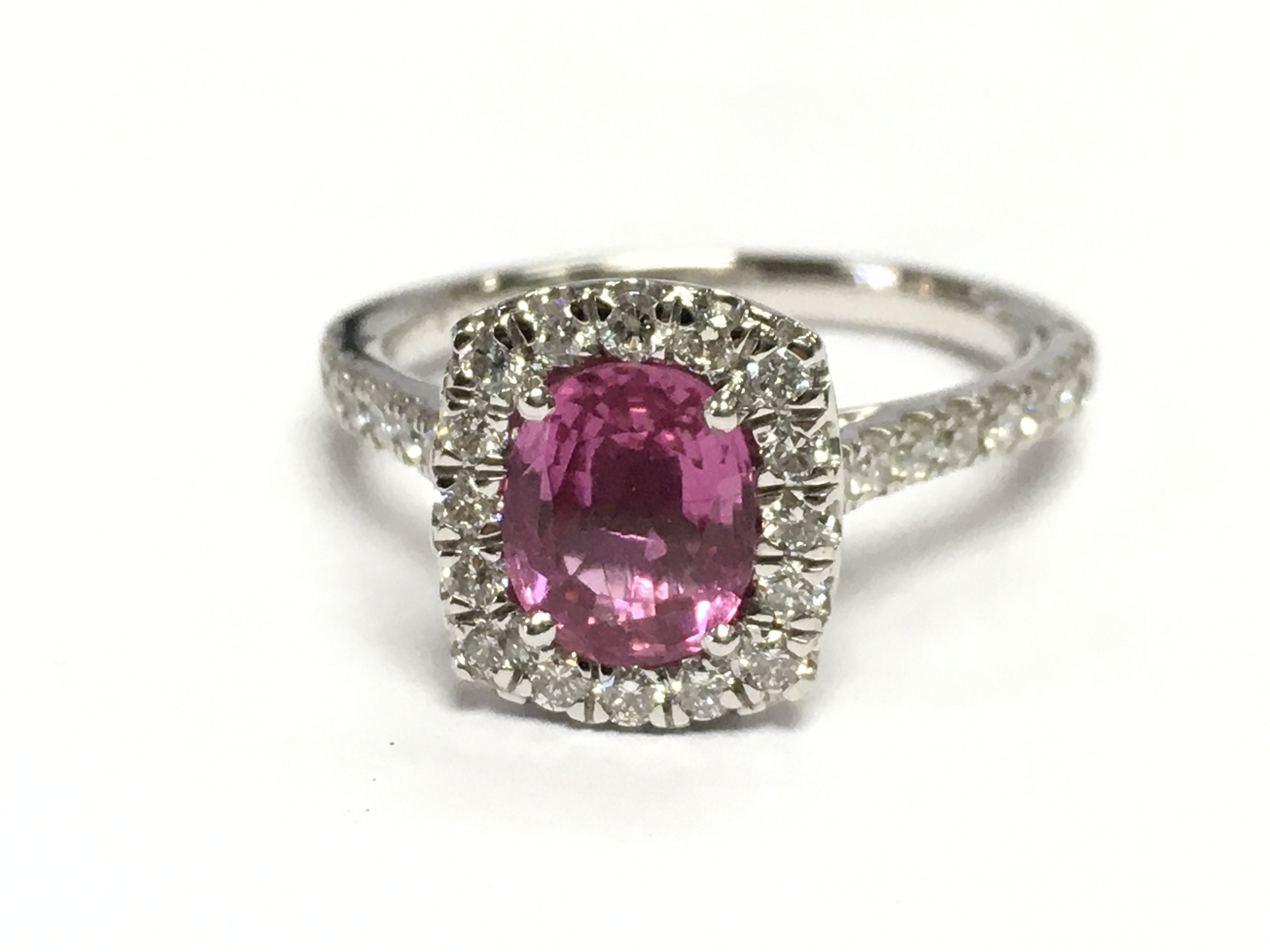 A platnium ring set with an oval pink sapohire surronded by RBC diamonds and diamond set shoulders. Pink sapphires 1.40ct diamonds 0.50ct. Size M weight 5.4g 