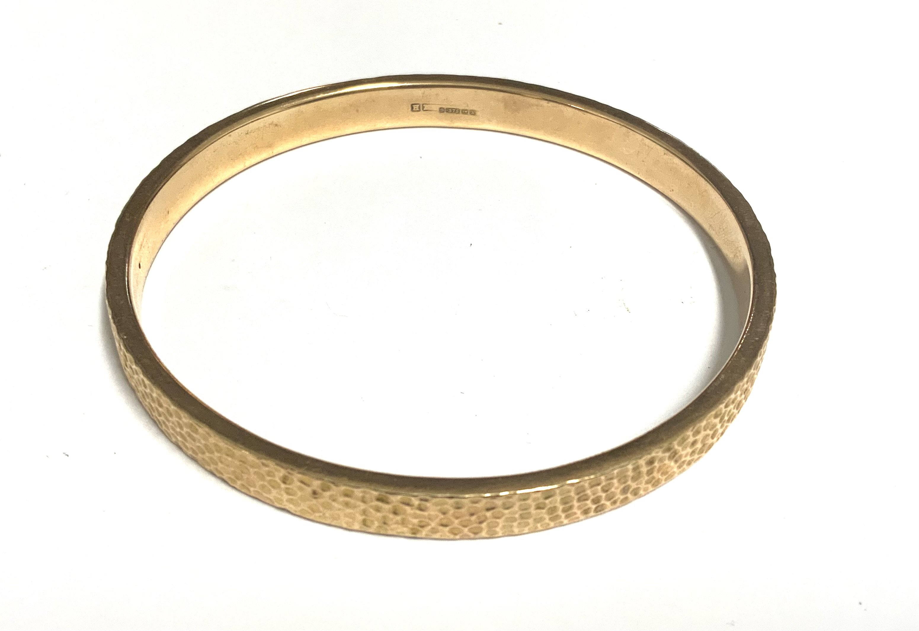 A 9ct gold bangle with hammered finish. 12.6g