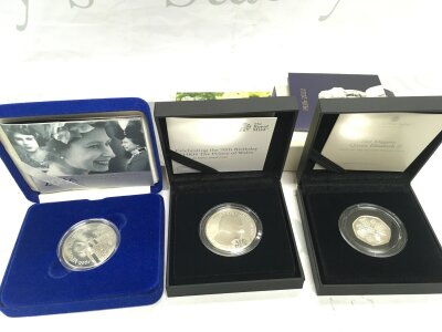 Three proof silver coins by royal mint including 50p Queen Elizabeth II coin.