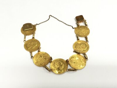 A gold bracelet made up of 7 ducat coins with 14ct gold links told all together. Total weight 30.75g