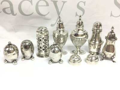 Silver condiments, eight pepper pots and two unmarked white lids