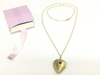 A silver gilt locket with gemstone and chain