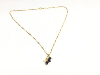 A 14ct gold chain with a sapphire floral design pendant. 3.97g