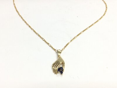 A 14ct gold chain with a sapphire hand pendant.