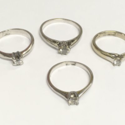 Four 9ct white gold diamond solitaire rings, total approx 10g.