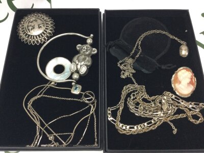 A small collection of sterling silver jewellery including necklaces, cameo brooch, teddy bangle, Egyptian style brooch etc,