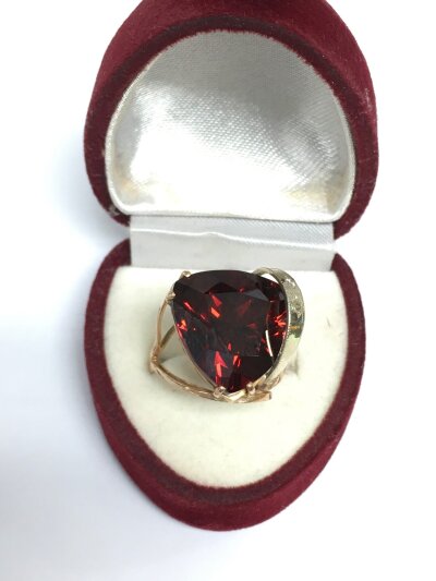 A rose gold ring set with a large red stone, approx 7.2g and approx size N-O.