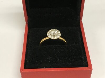 An 18ct god ring set set with a central brilliant cut diamond with a halo of other diamonds approx 0.62ct, approx