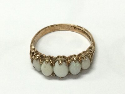 A 9ct gold r8g set with 5 opal stones. Size R 1/2 and 3.47g