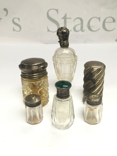 Six silver topped scent bottles.