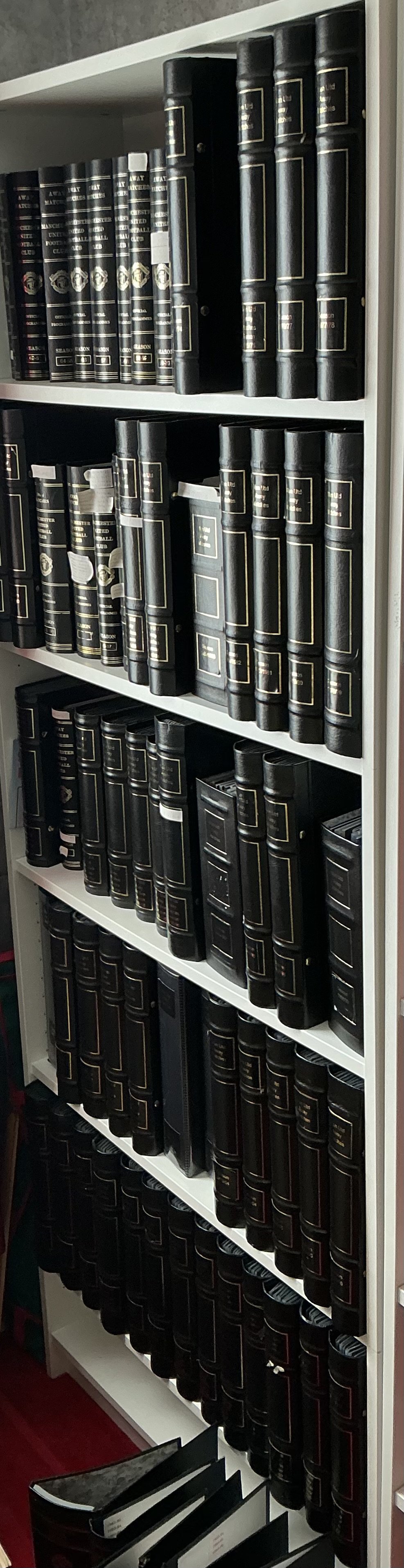 Manchester United Away Football Programme Collection In Binders: Stunning collection of 54 seasons in attractive black binders some official and some expensively made all with Manchester United and season in gold to spines. Including a few spares there are 73 binders with programmes from 61/62 to 2015/16 and a few earlier. Whilst this is from probate we feel this would be near complete of domestic programmes as there are a few labels only on spine which we believe are programmes missing. Rare chance. 