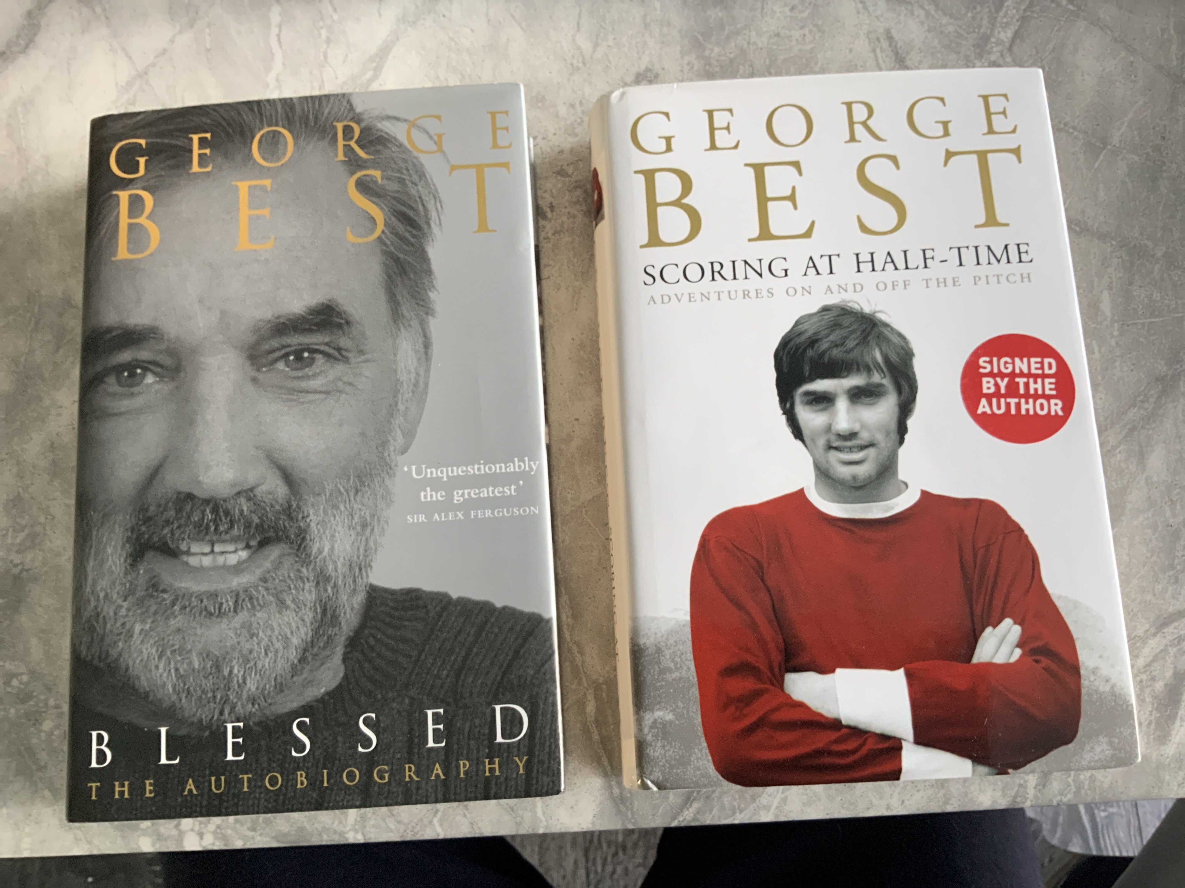 George Best Manchester United Signed Football Books: Scoring At Half Time clearly signed in biro. Blessed autobiography is signed in marker pen and has cut out pictures of Best stuck to inside page around autograph. Both undedicated. (2)