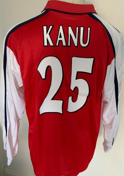 2001 - 2002 Arsenal Kanu Match Worn Football Shirt: Long sleeve red Dreamcast shirt with Champions League badging and number 25 Kanu to rear. Worn in match v Deportable La Corunna on 21 11 2001. COA signed by Kanu. Very light staining to sleeve whete mud has not washed out.