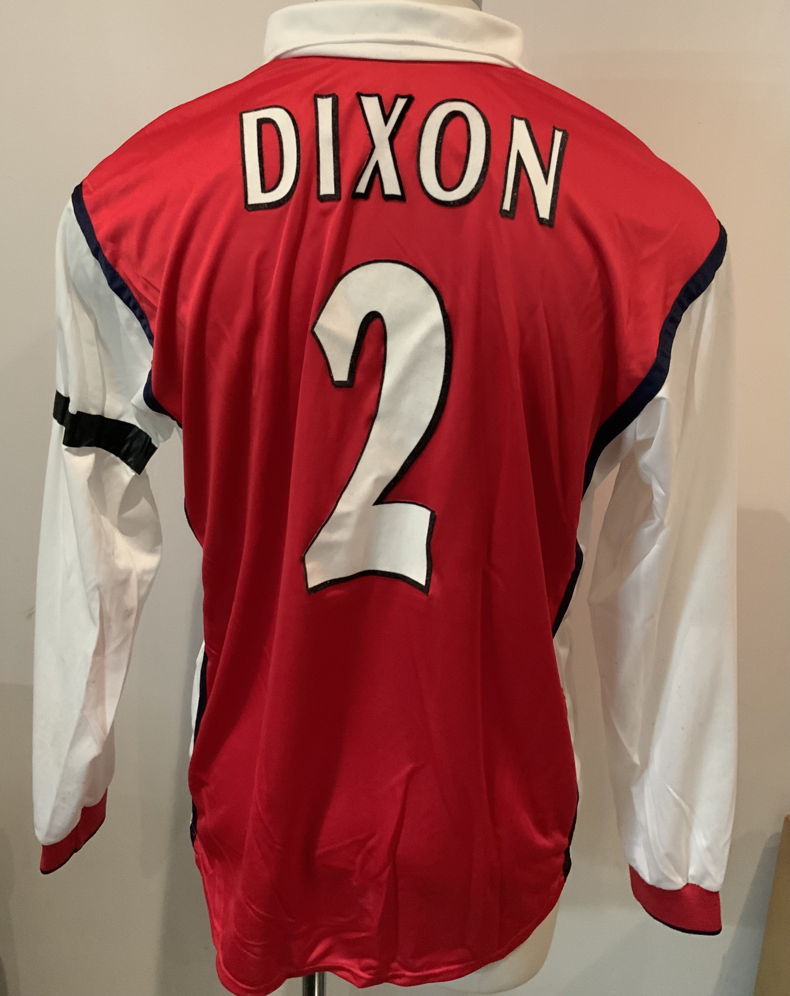 Arsenal Dixon 1999 - 2000 Match Worn Home Football Shirt: Nike red long sleeve shirt with Dreamcast sponsorship. Dixon 2 to rear. Whilst washed there is a small amount of mud marks to white sleeve and tape attached to top of left sleeve. Worn by Lee Dixon v Deportivo La Coruna on 2 3 2000 with a COA signed by him. Photographic proof on picture of him scoring the first goal.