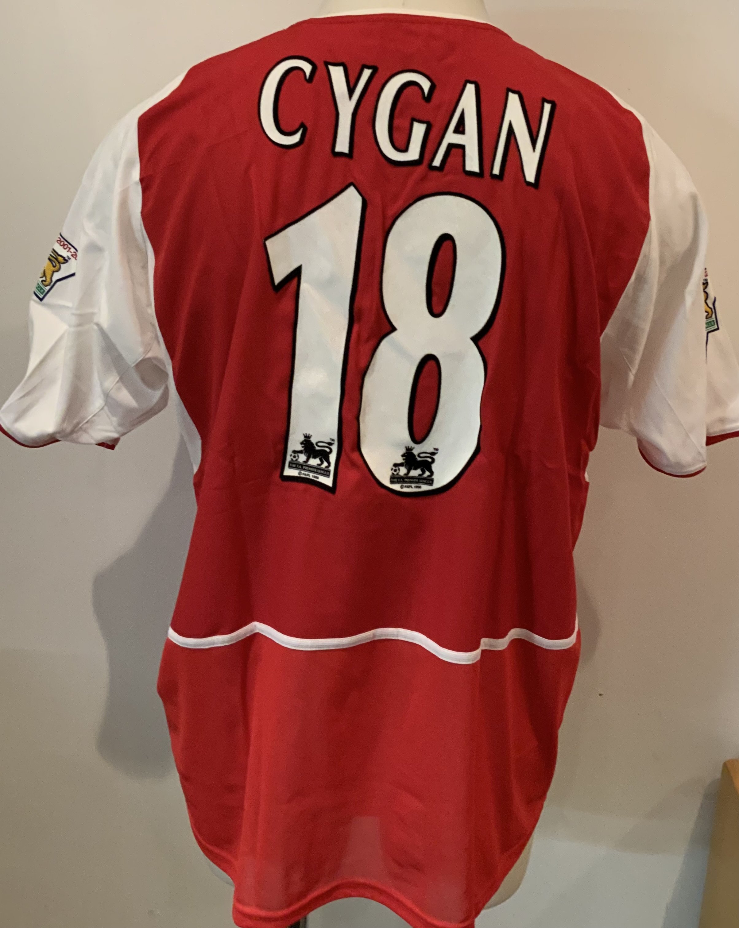 Arsenal 2002 - 2003 Match Worn Home Football Shirt: Nike red short sleeve shirt with O2 sponsorship. Cygan 18 to rear and Premier League Winners 2001/2002 sleeve badging. Inner mesh still attached. Worn by Cygan v Chelsea on 1 9 2002 with a COA signed by him.
