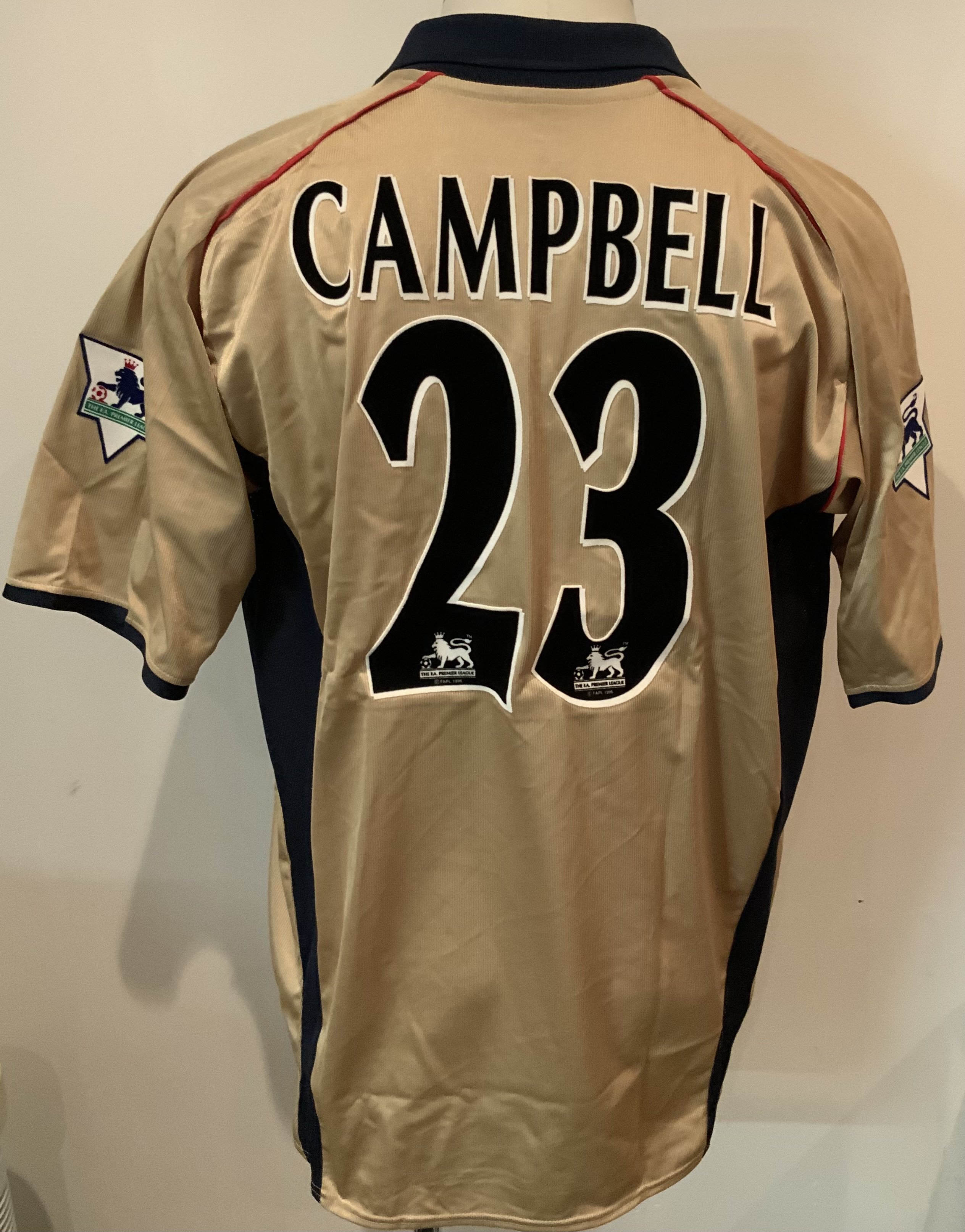 Arsenal 2001 - 2002 Gold Sega Match Worn Football Shirt: Nike iconic gold short sleeve shirt with blue collar and Sega sponsorship. Campbell 23 to rear. Worn by Sol Campbell v Southampton on 13 10 2001 with a COA signed by him.