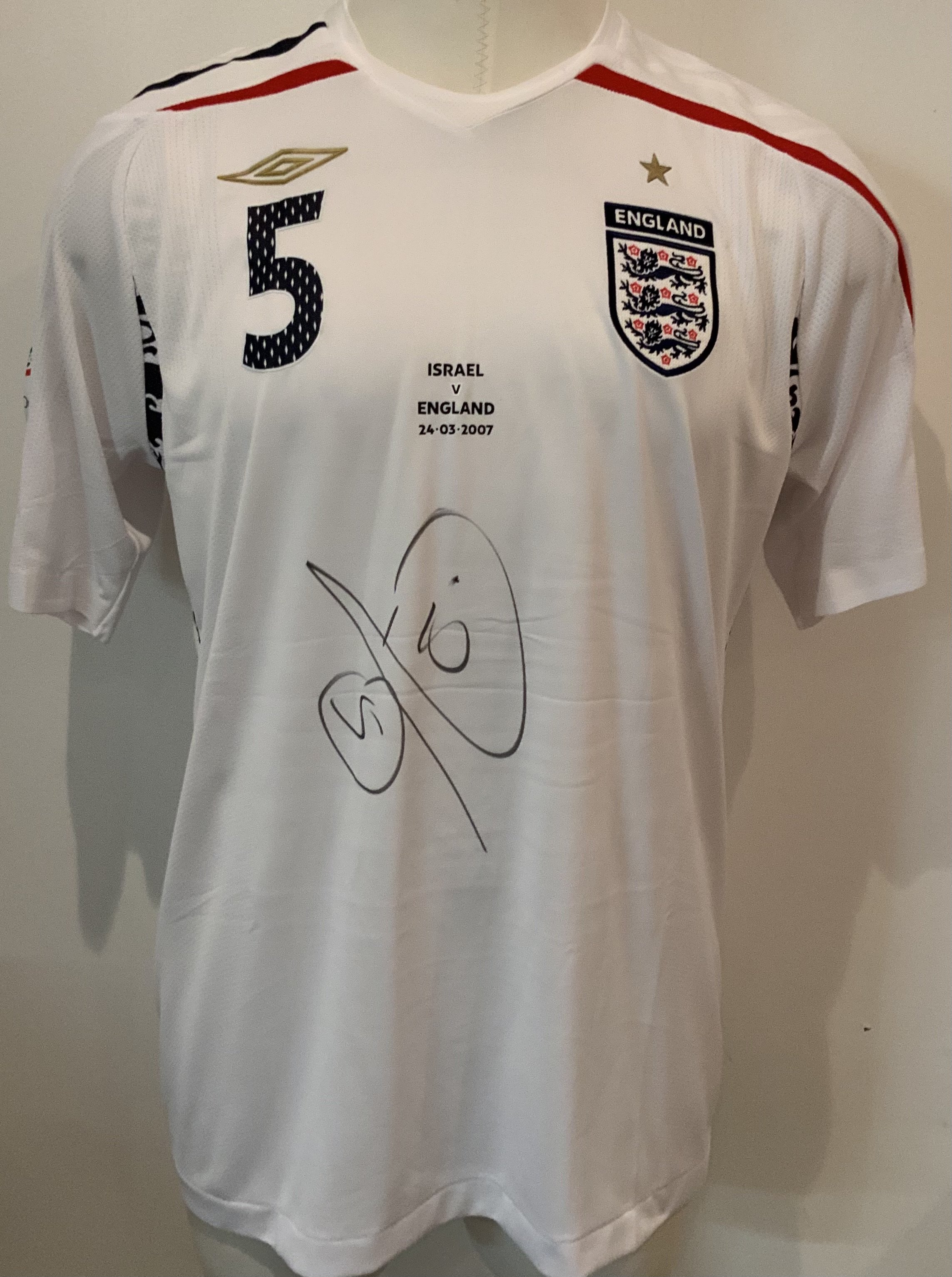 England Rio Ferdinand 2007 Match Worn Football Shirt: Umbro short sleeve shirt with Ferdinand 5 to rear and Euro 2008 badging to sleeve. Number 5 to front match details Israel v England 24 03 2007 and Rio Ferdinands autograph. Direct from top source who we know. The Manchester United player played the whole match in a 0-0 draw in Tel Aviv.