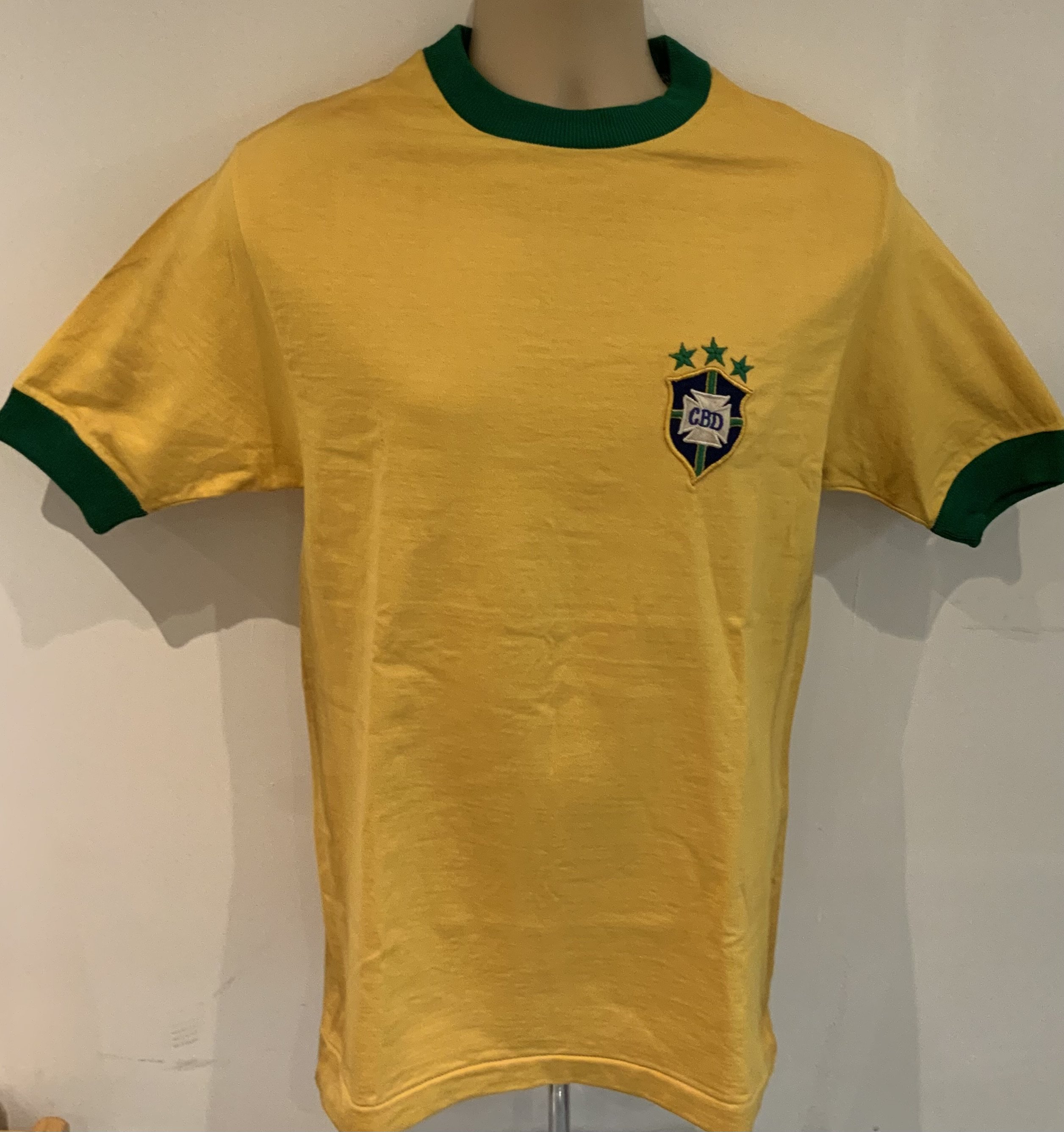 Gerson 1971 ( Match Worn )Brazil Shirt: Yellow number 8 short sleeve shirt. Made by Athleta. Label stitching on number and badge look original. COA from source in Brazil which states this came from the masseur. Photo identification of original seller from Brazil. We have asked an expert at gamewornfootballshirts and whilst the shirt is original and has all the credentials to be a shirt from that period they inform me even with this paperwork they do not ever accept coas from South America and the seller from Brazil has sold previously similar items for tens of thousands. For that reason this shirt is to be sold by us as a signed original shirt from the period only and not match worn.