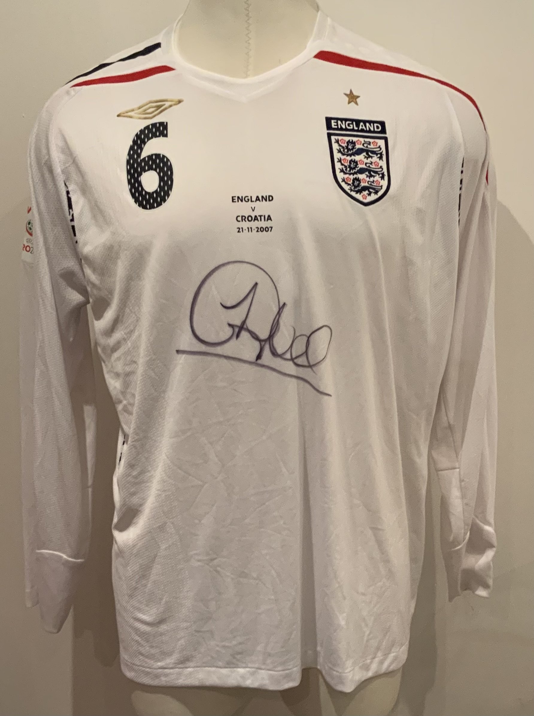 2007 England Match Worn Signed Football Shirt: White long sleeve number 6 Umbro shirt worn by Sol Campbell v Croatia on 21 November 2007 in World Cup qualifier. Good condition and signed to front by the player.