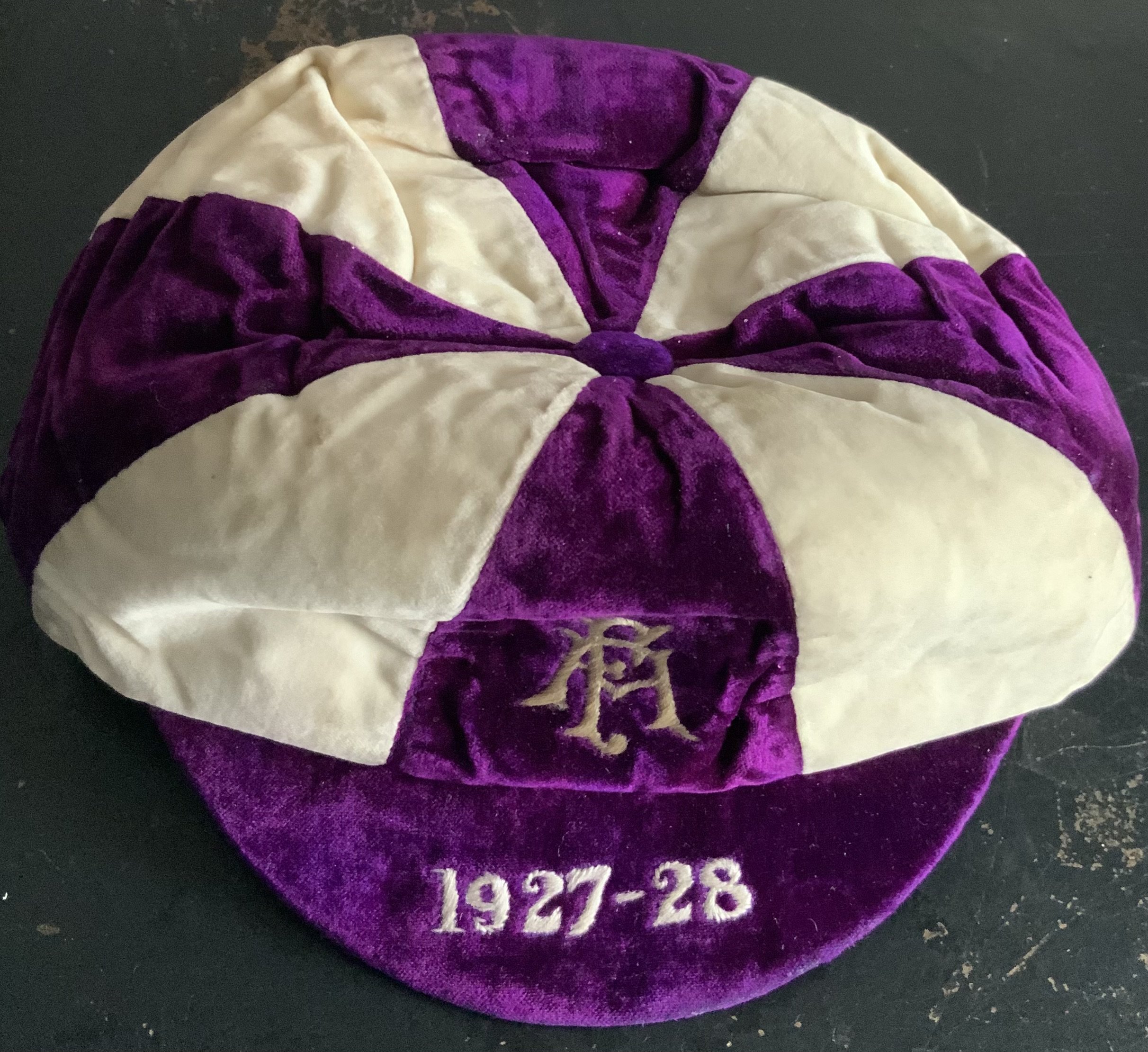 England 1927/28 FA International Trial Football Cap: Good condition purple and white cap awarded to Huddersfield Town player Roy Goodall. Goodall was capped 25 times and captained England 12 times. Rare item.