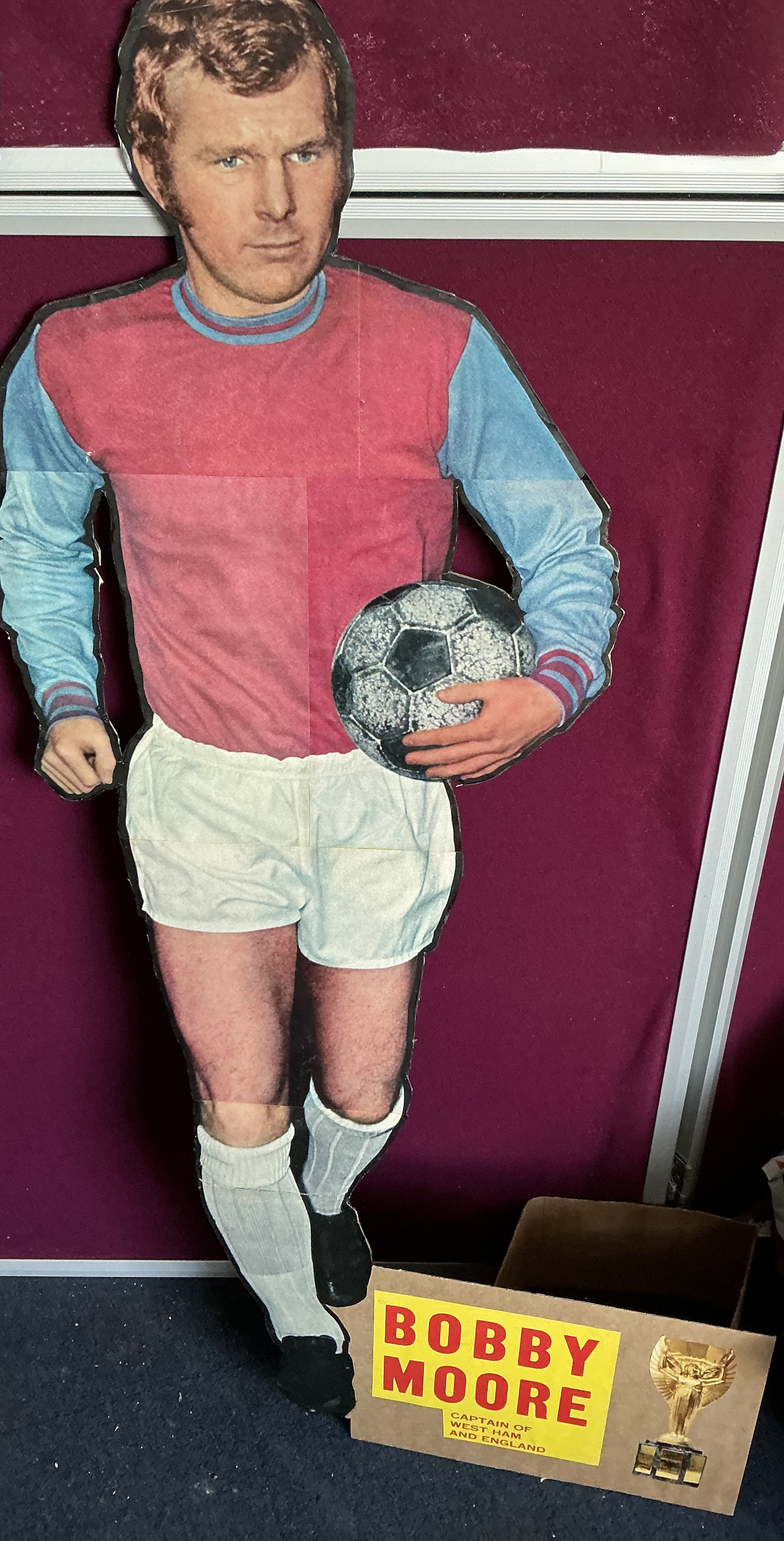 Bobby Moore West Ham Large Cardboard Promotional Display: 42 inch high cardboard cut out of Bobby Moore in West Ham kit with the World Cup believed to be promoting a magazine in the 60s. C/W magazines and pictures of Bobby.