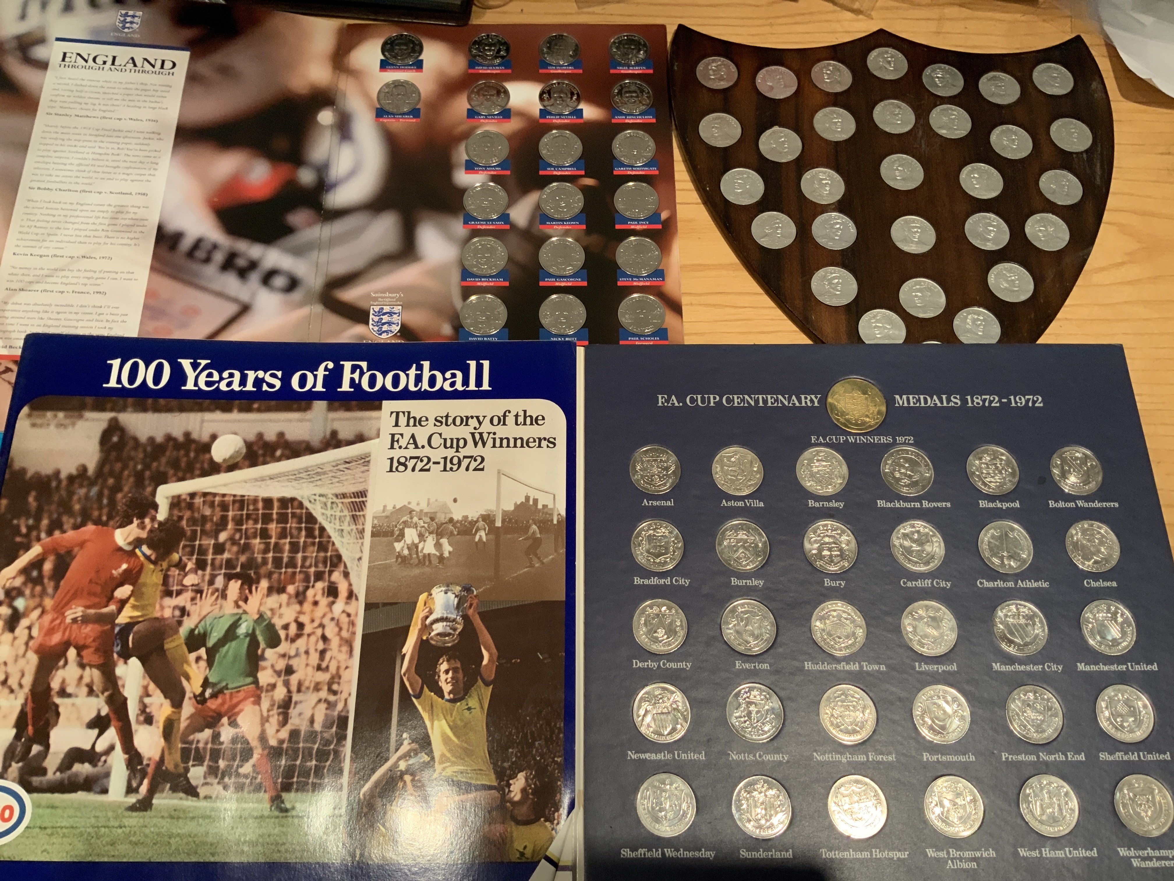 Football Coin Sets: Esso 1970 World Cup full set stuck into wooden shield that could be hand made. 1972 FA Cup Centenary is also complete in album. C/W 1998 Sainsburys full World Cup set and some other loose coins. (3 sets)
