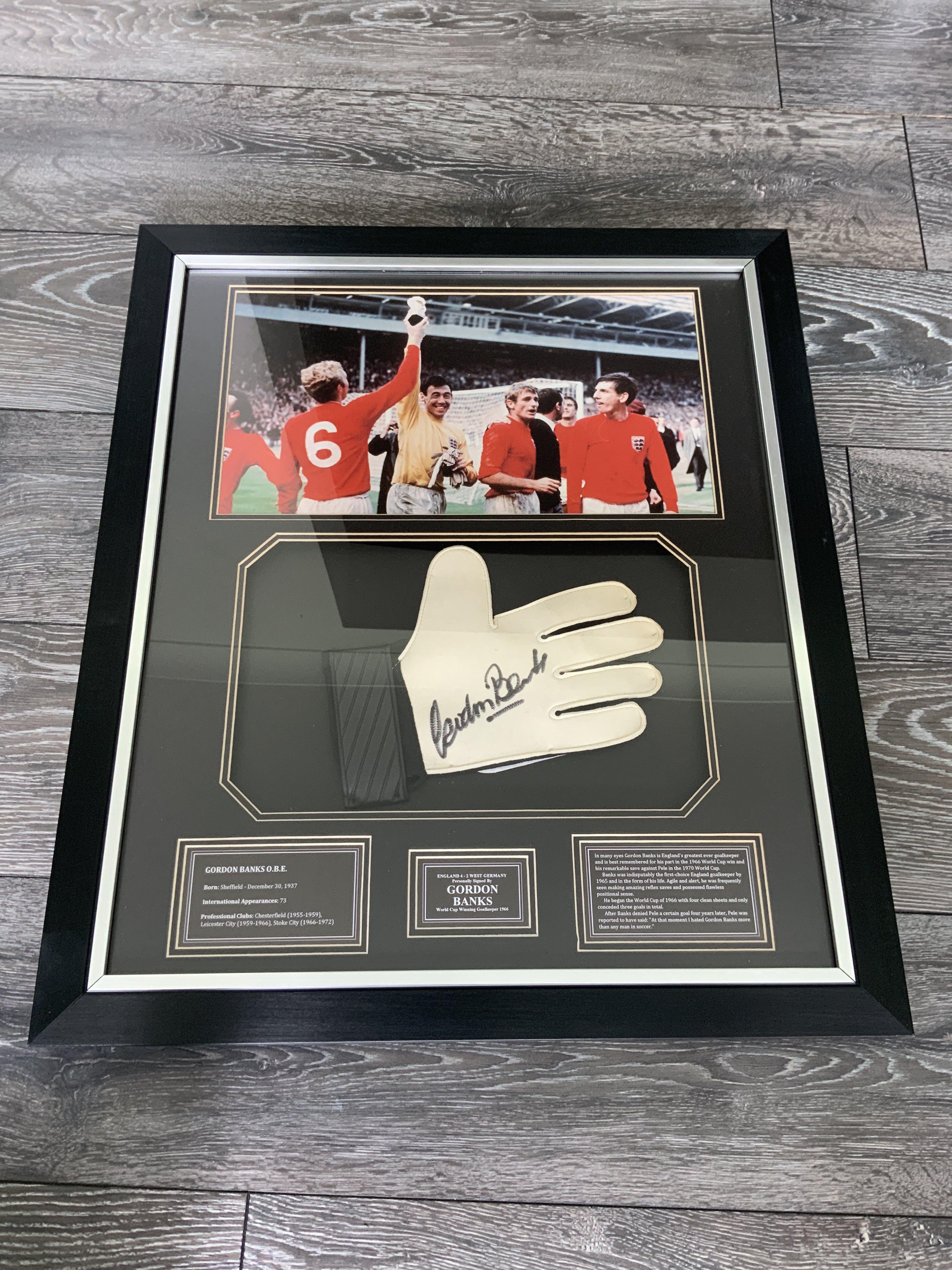 Gordon Banks England 1966 World Cup Signed Framed Glove: Beautifully framed glove hand signed by Banks with a picture of him celebrating on the pitch with team mates. Quality item which would have cost hundreds of pounds when new. Measures 58 x 68 cm.