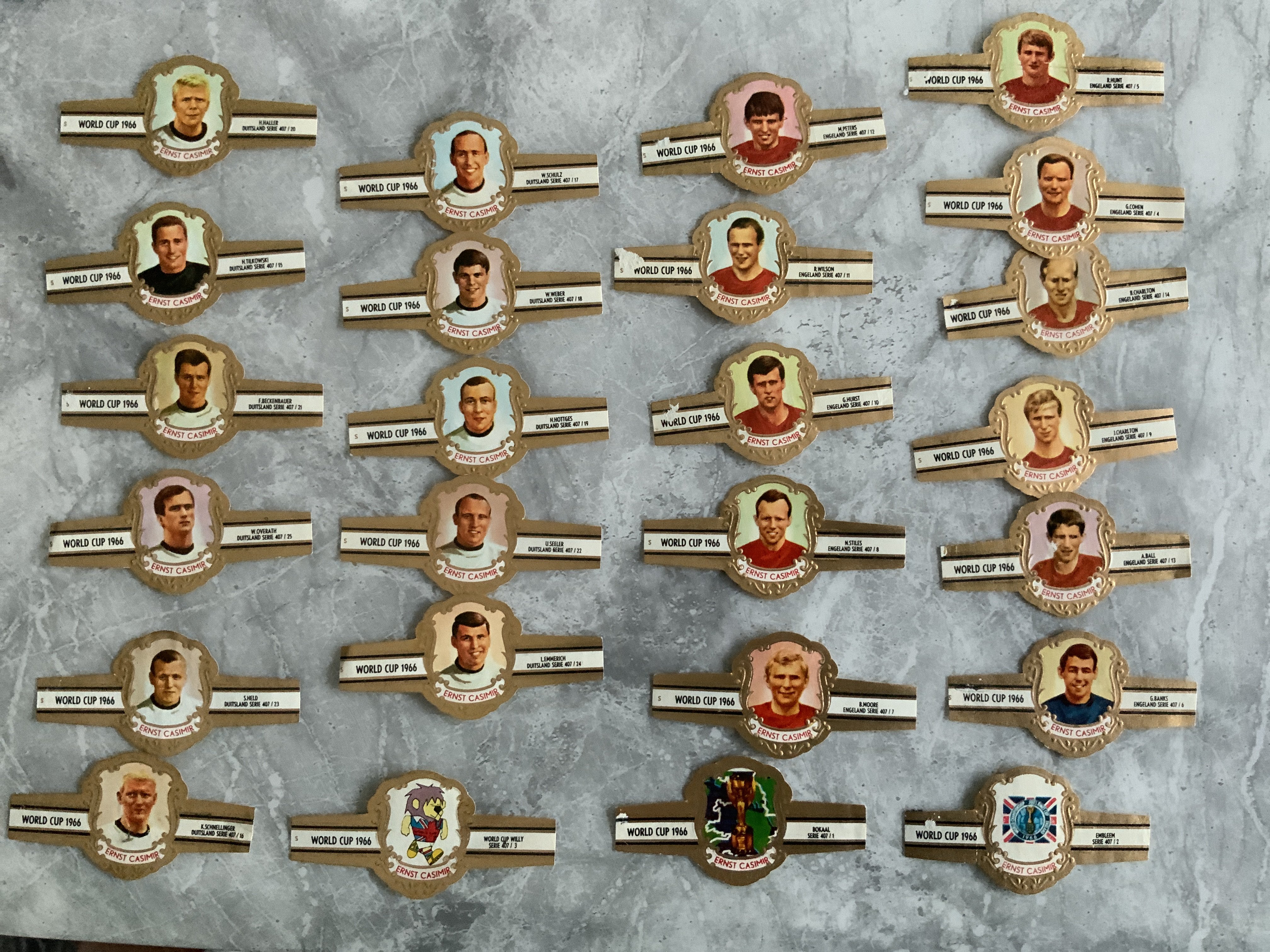 1966 Football World Cup Final Cigar Bands: Full set of 25 which consist of both England and West Germany players in the final plus 3 World Cup logos including WC Willie. Good with a couple having a tiny scuff not affecting photos. (25)